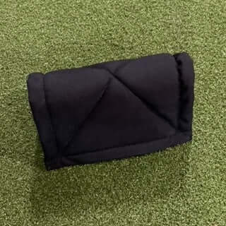JDUB Pine Tar Rag in black on a green turf surface, ideal for applying pine tar to baseball bats.
