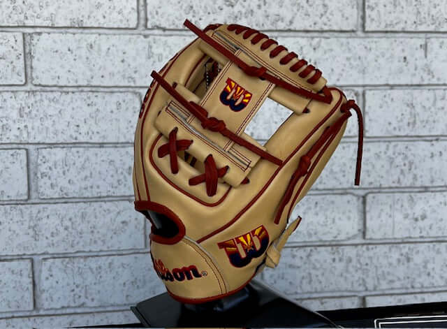 Wilson A2000 AZ Flag Logo 1786 BTL Exclusive 11.5 baseball glove on display against a brick background.