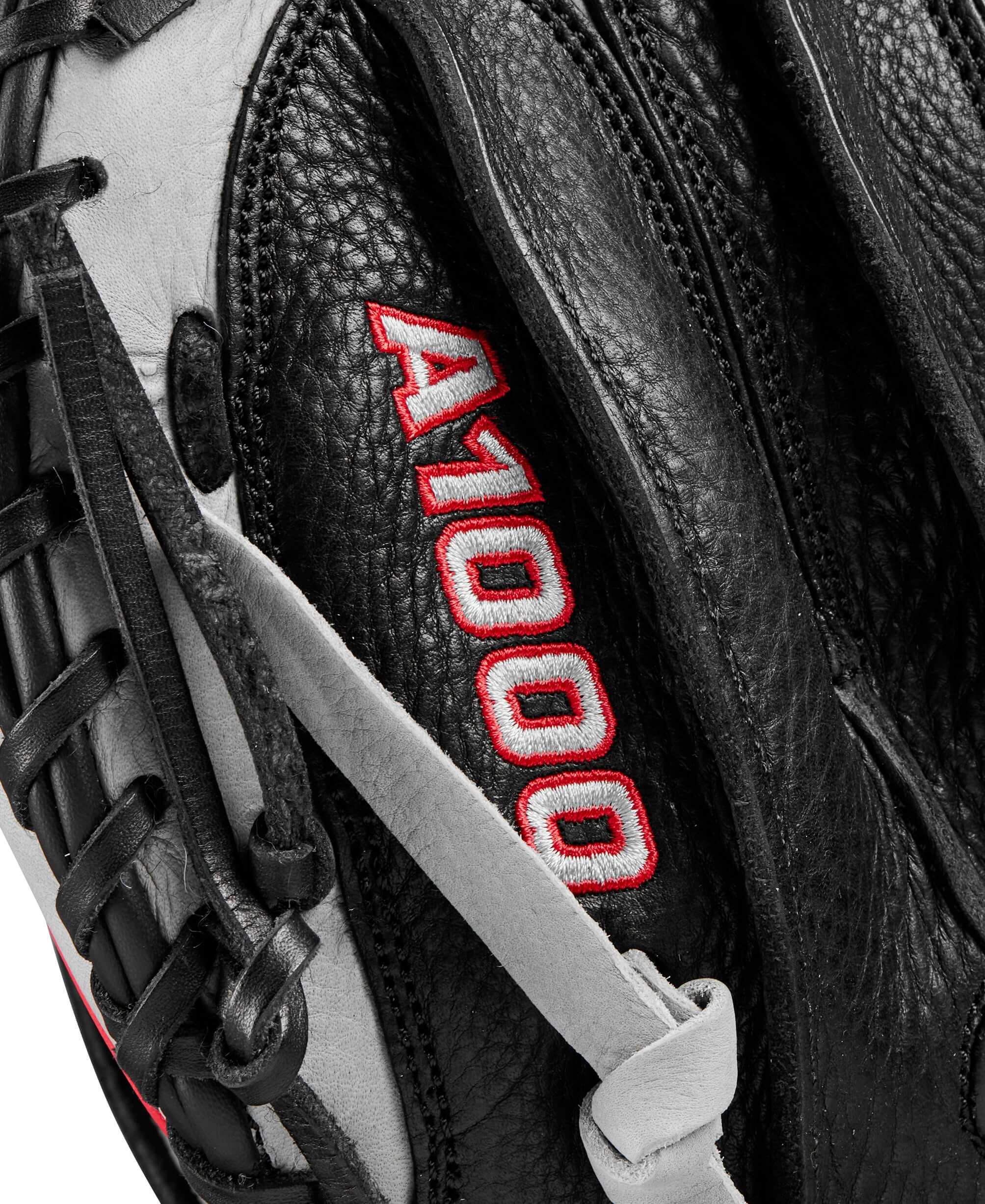 Close-up of Wilson A1000 CM33 catcher’s mitt showcasing detailed stitching and logo in silver, black, and red colors.