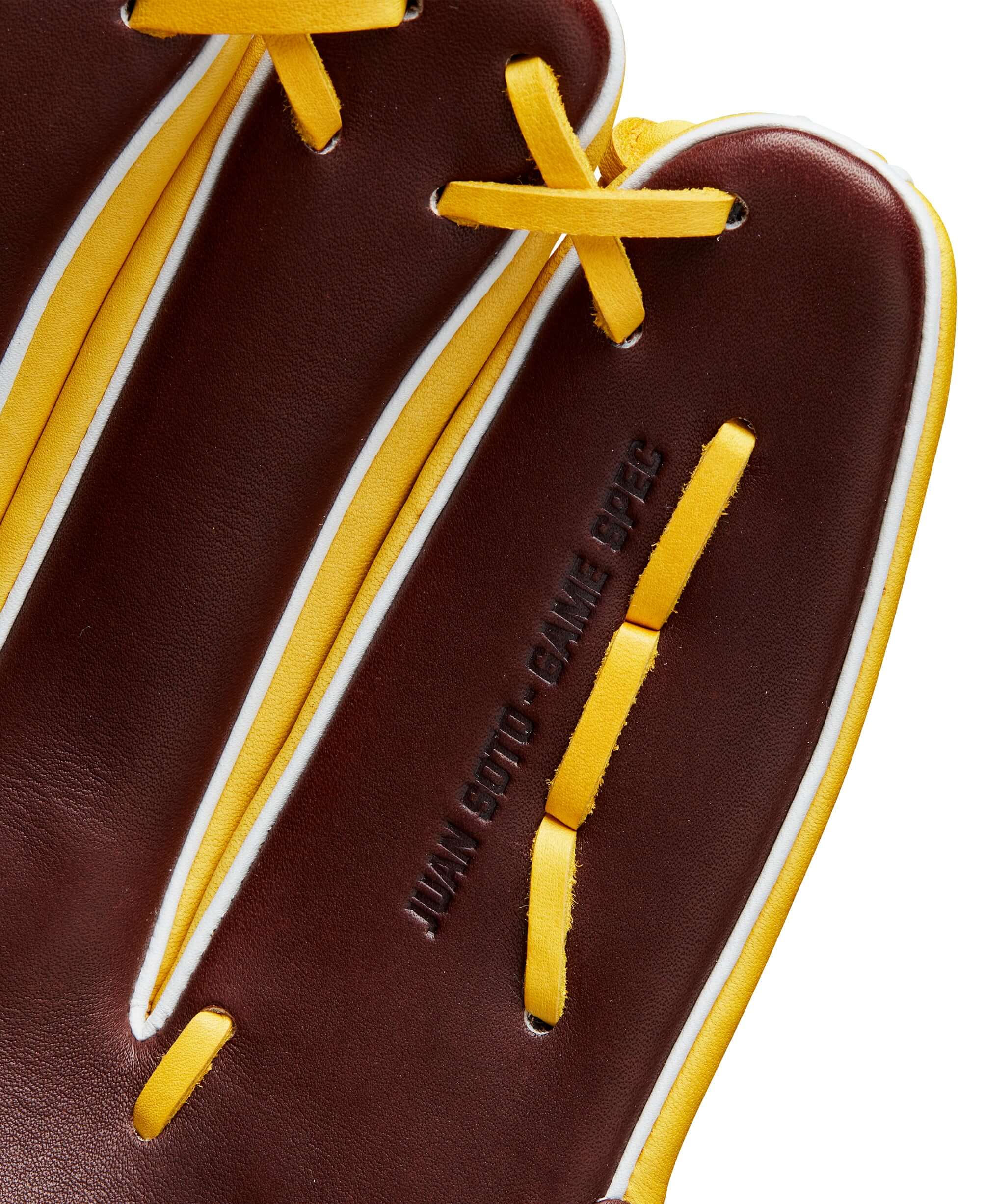 Close-up of Wilson A2K Juan Soto glove showing rich brown leather and yellow accents with Juan Soto's stamp.