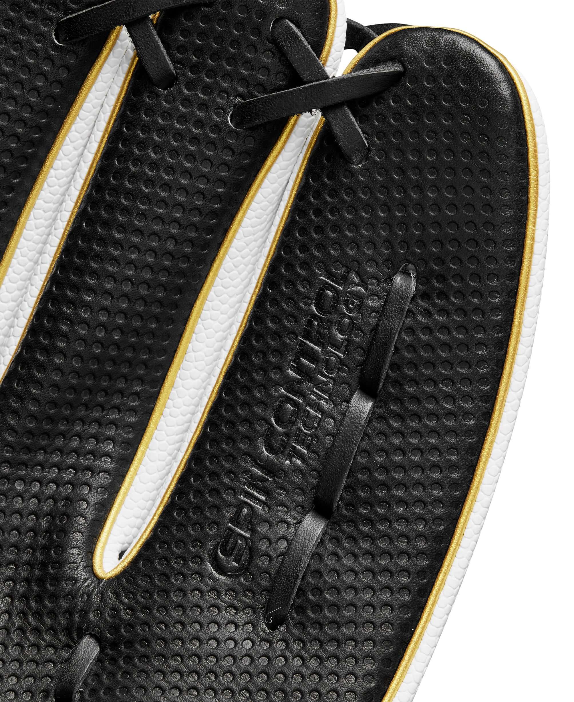 Close-up of Wilson A2000 glove showing black leather texture and gold accents, highlighting Spin Control Technology.