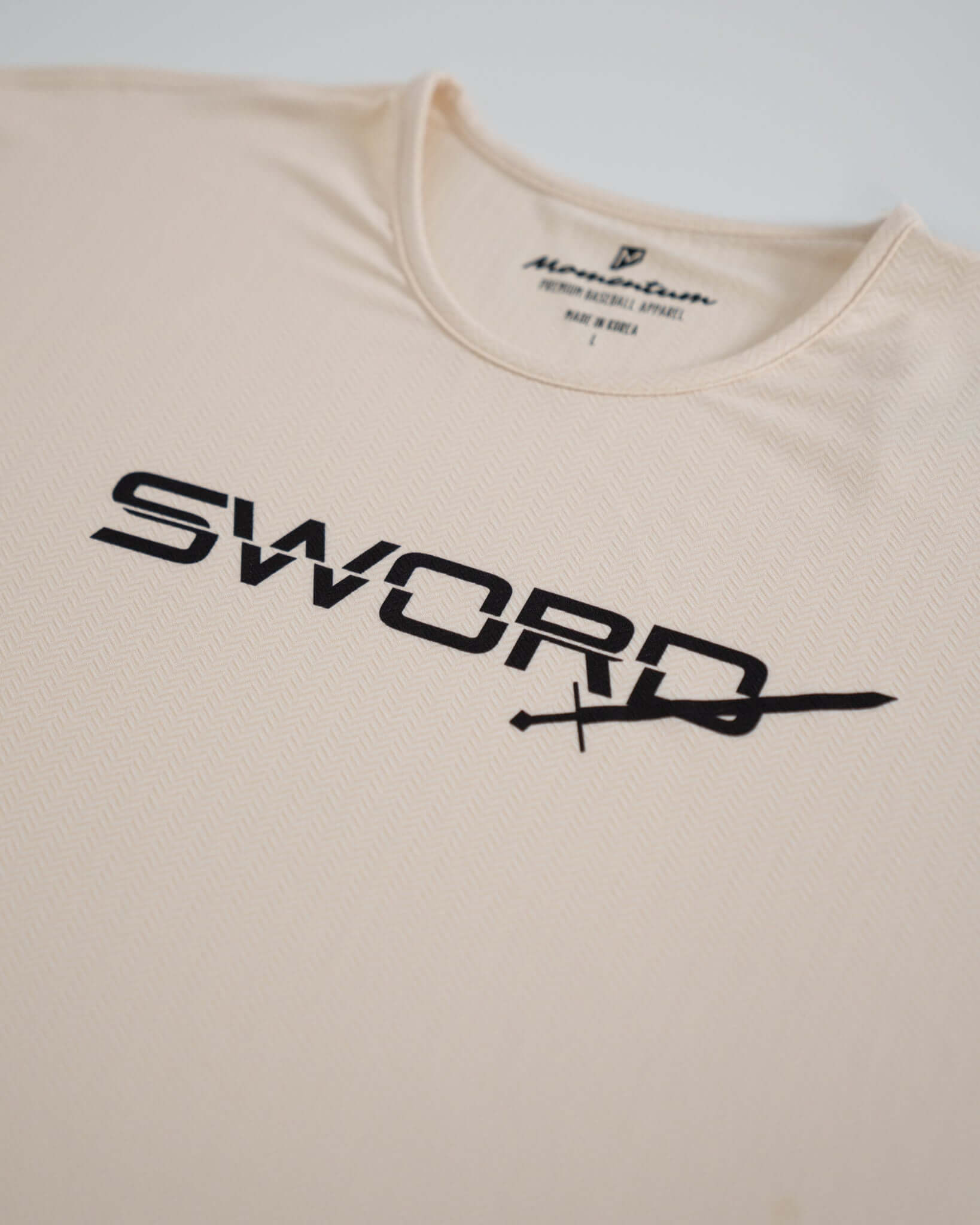 Bauer Outage Tan Recovery Tee featuring black 'SWORD' logo on soft, breathable fabric for post-workout comfort.