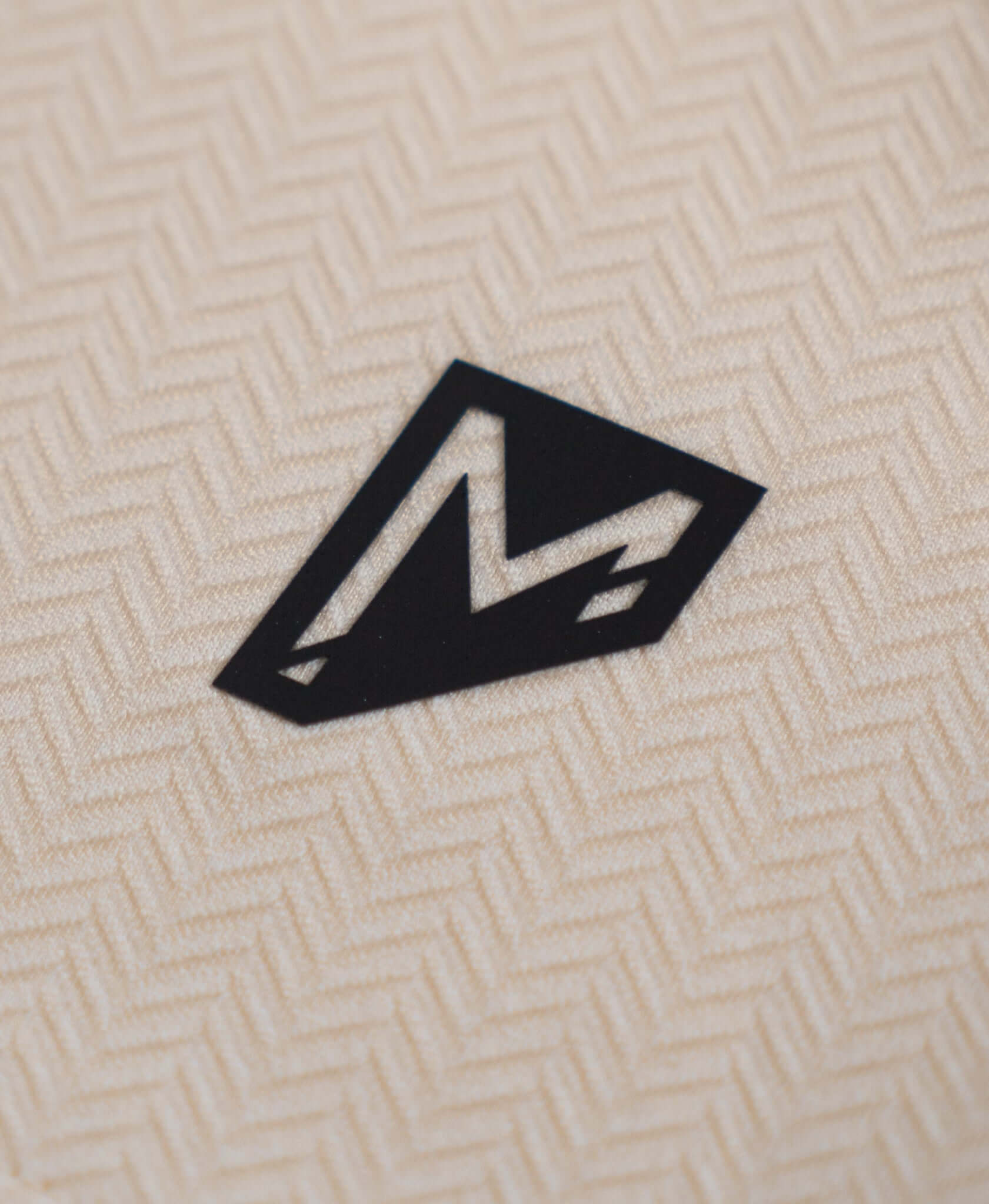 Close-up of Bauer Outage Tan Recovery Tee logo on breathable fabric, showcasing premium quality and design.