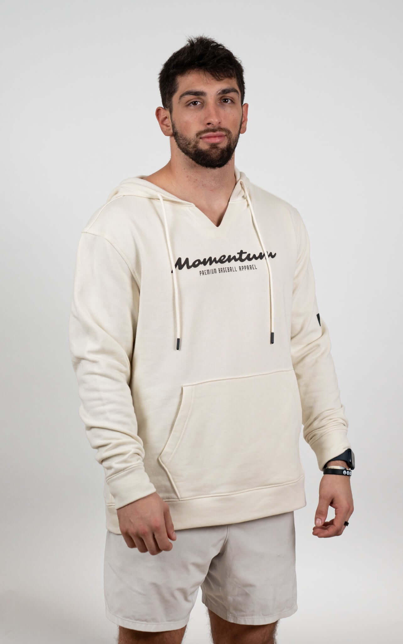 Man in a tan Momentum Heavyweight Hoodie, showcasing a notch-neck collar and oversized fit for ultimate comfort.