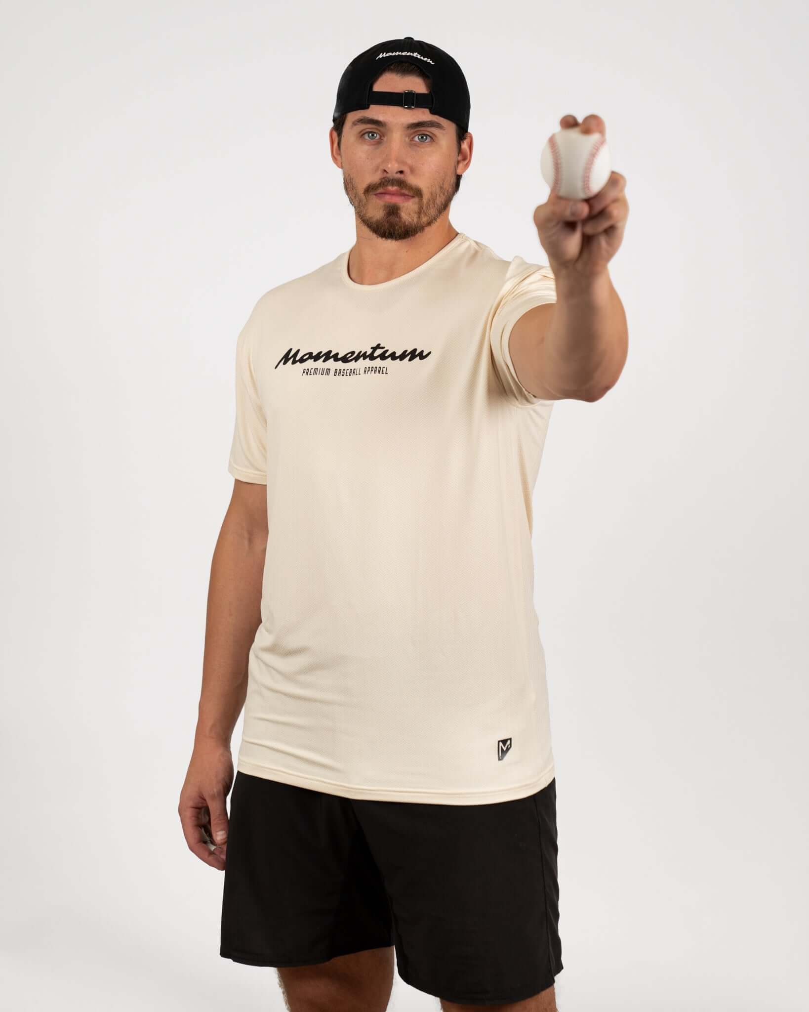 Man wearing a Momentum Tan Recovery Tee, holding a baseball, showcasing oversized fit and breathable design.