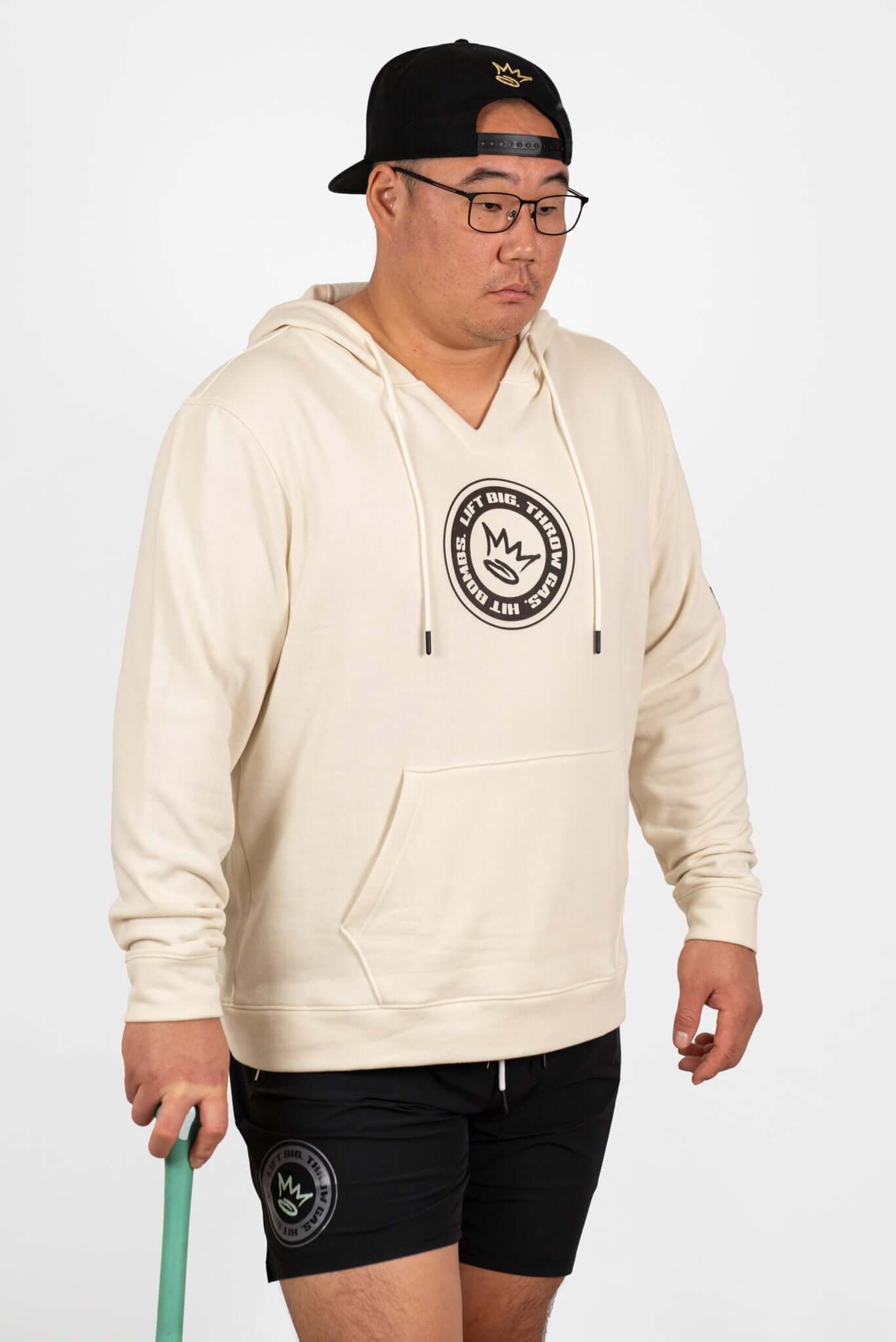 King of Juco Tan Heavyweight Hoodie worn by a man, featuring a logo, ideal for post-training comfort and recovery.