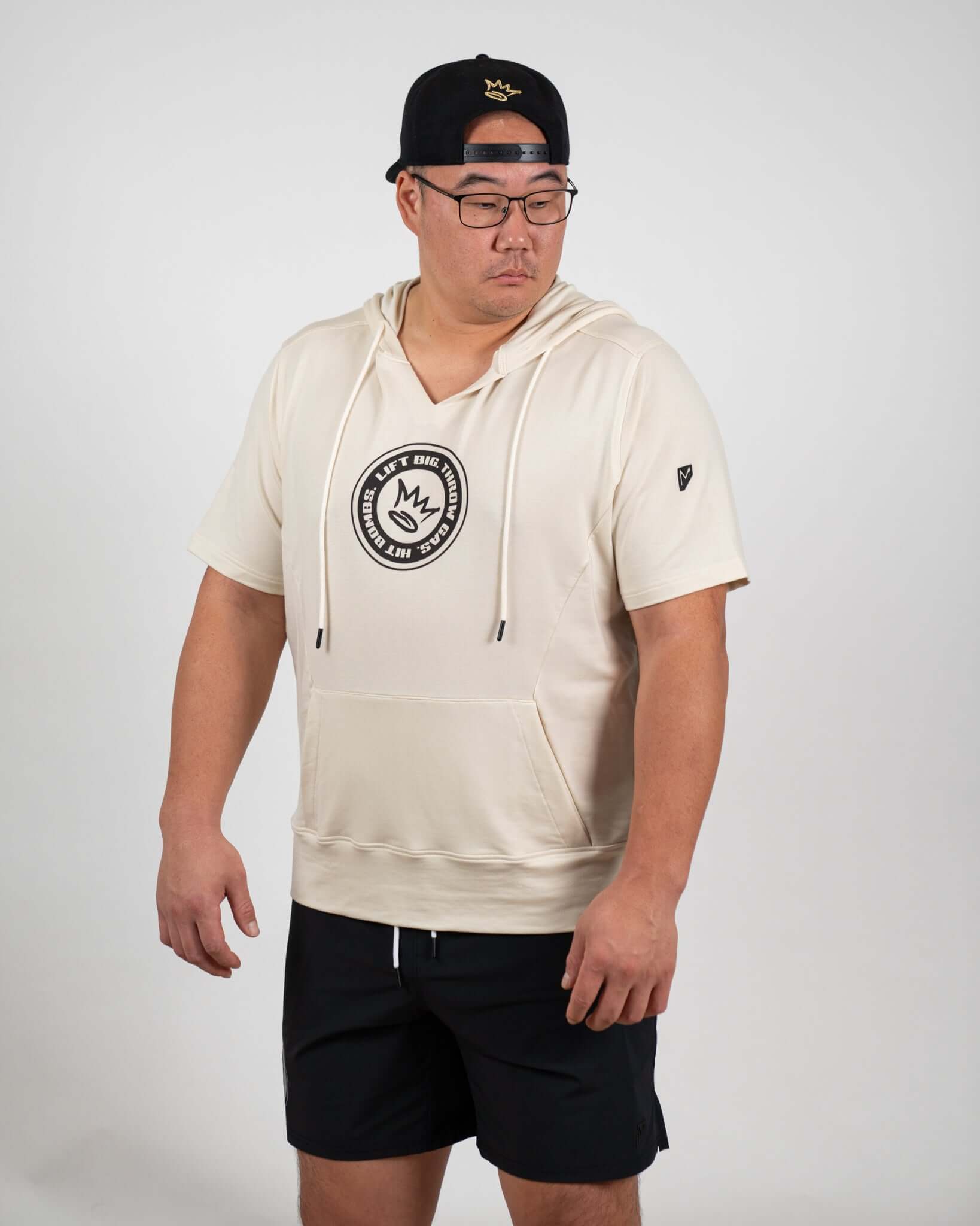 King of Juco Tan Short Sleeve Hoodie on model, featuring notch-neck collar and logo, ideal for workouts and casual wear.