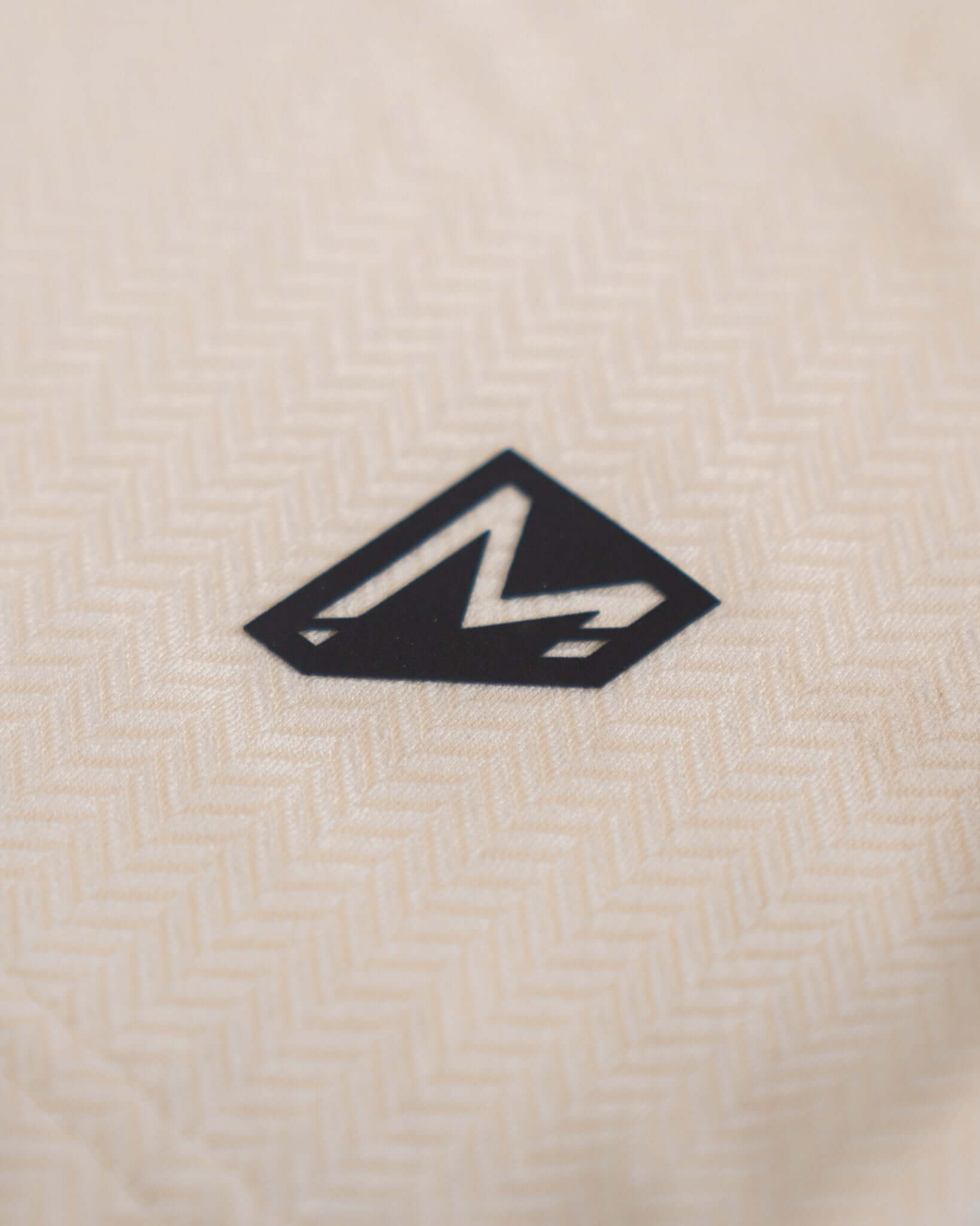 Close-up of the Momentum brand logo on tan fabric, showcasing quality and stylish design.