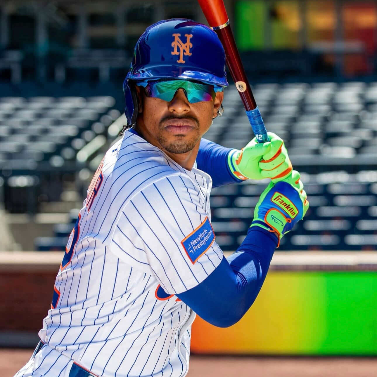 Young baseball player wearing Franklin Lindor Limited Edition Batting Gloves, ready to hit, showcasing vibrant colors.