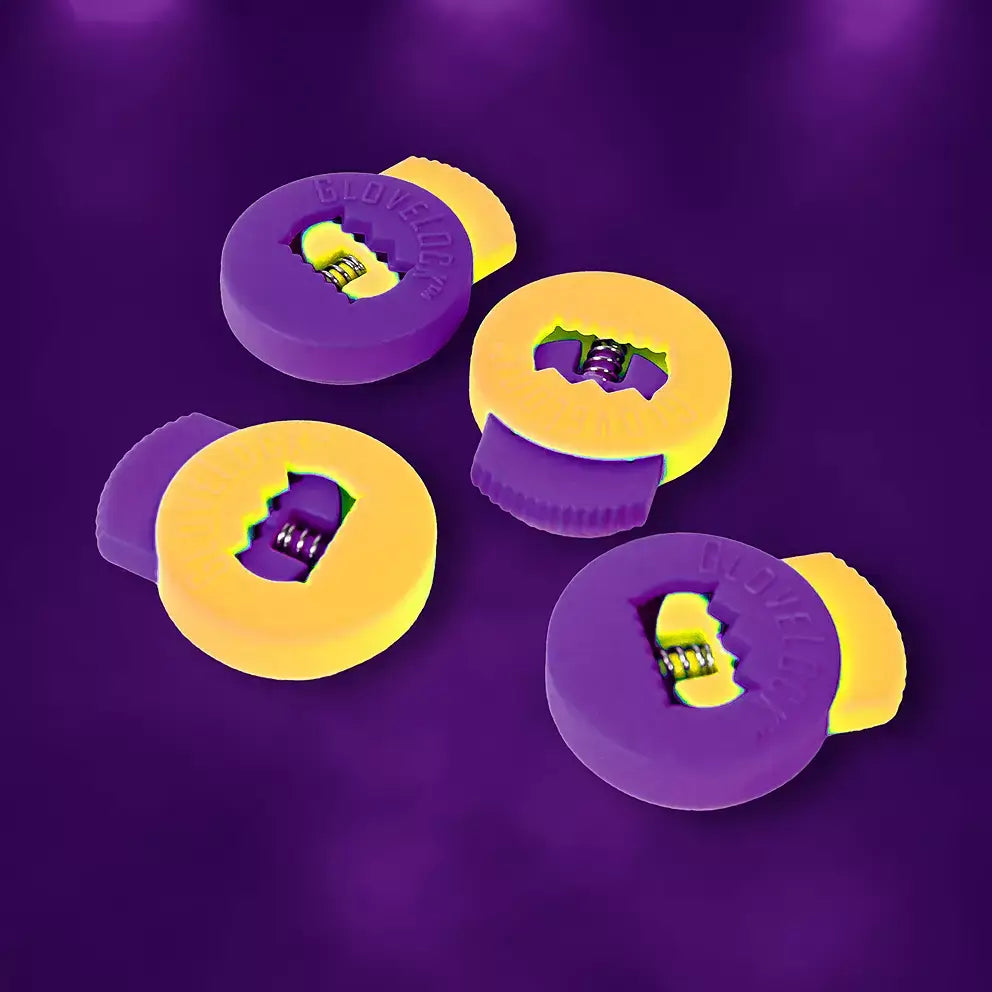 Four All-Star Glovelocks 4 Pack Lace Clips Limited Edition in vibrant yellow and purple on a dark purple background.