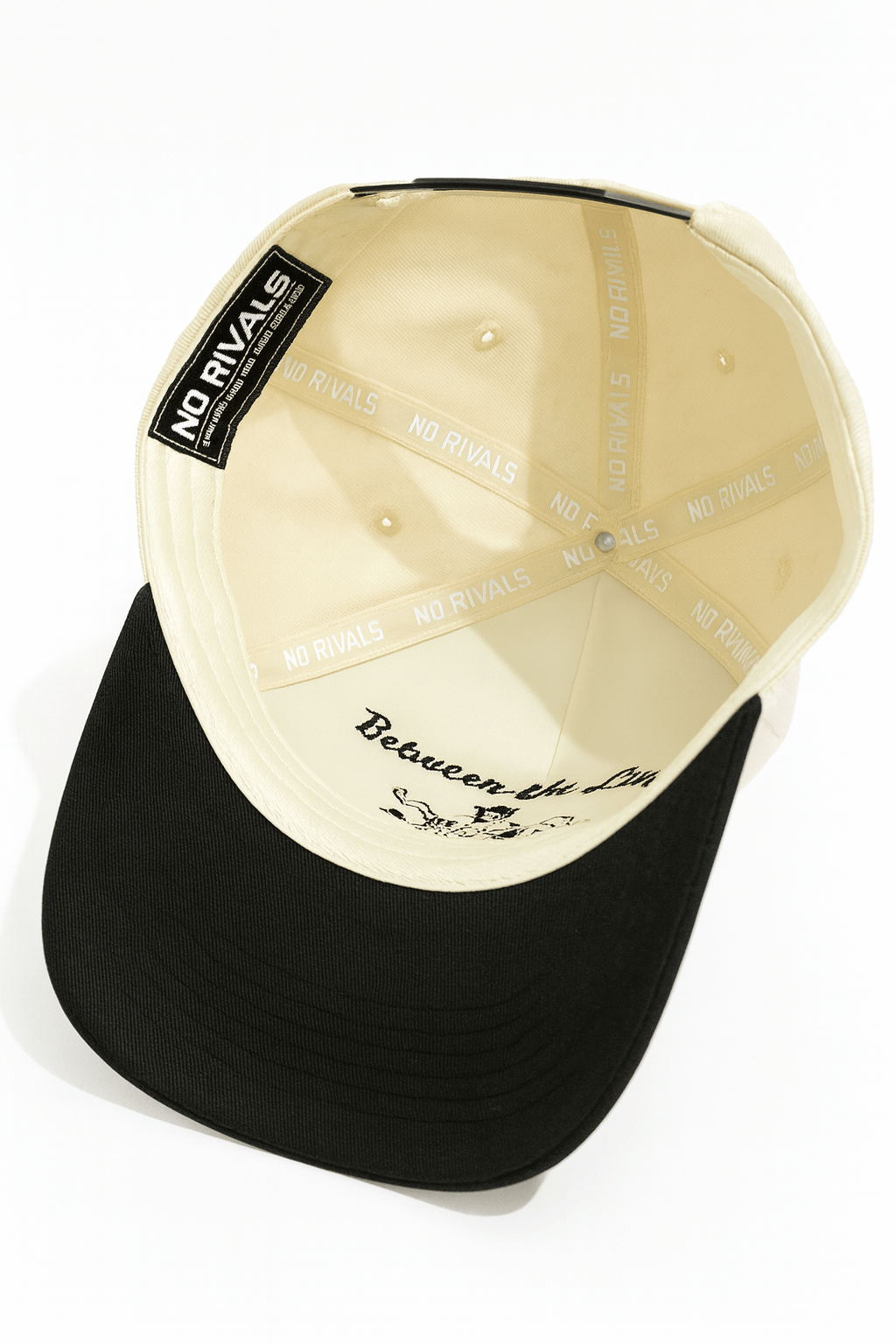 Black and beige cap with 'No Rivals' label on a white background