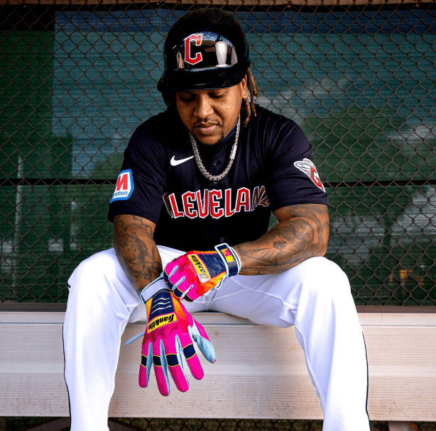 Franklin Jose Ramirez Limited Edition CFX Pro Youth gloves worn by athlete on bench, palm view, multicolor design.