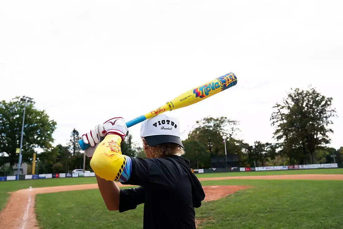 Player preparing to swing the Victus Nova LIT (-8) USSSA Baseball Bat on baseball field.