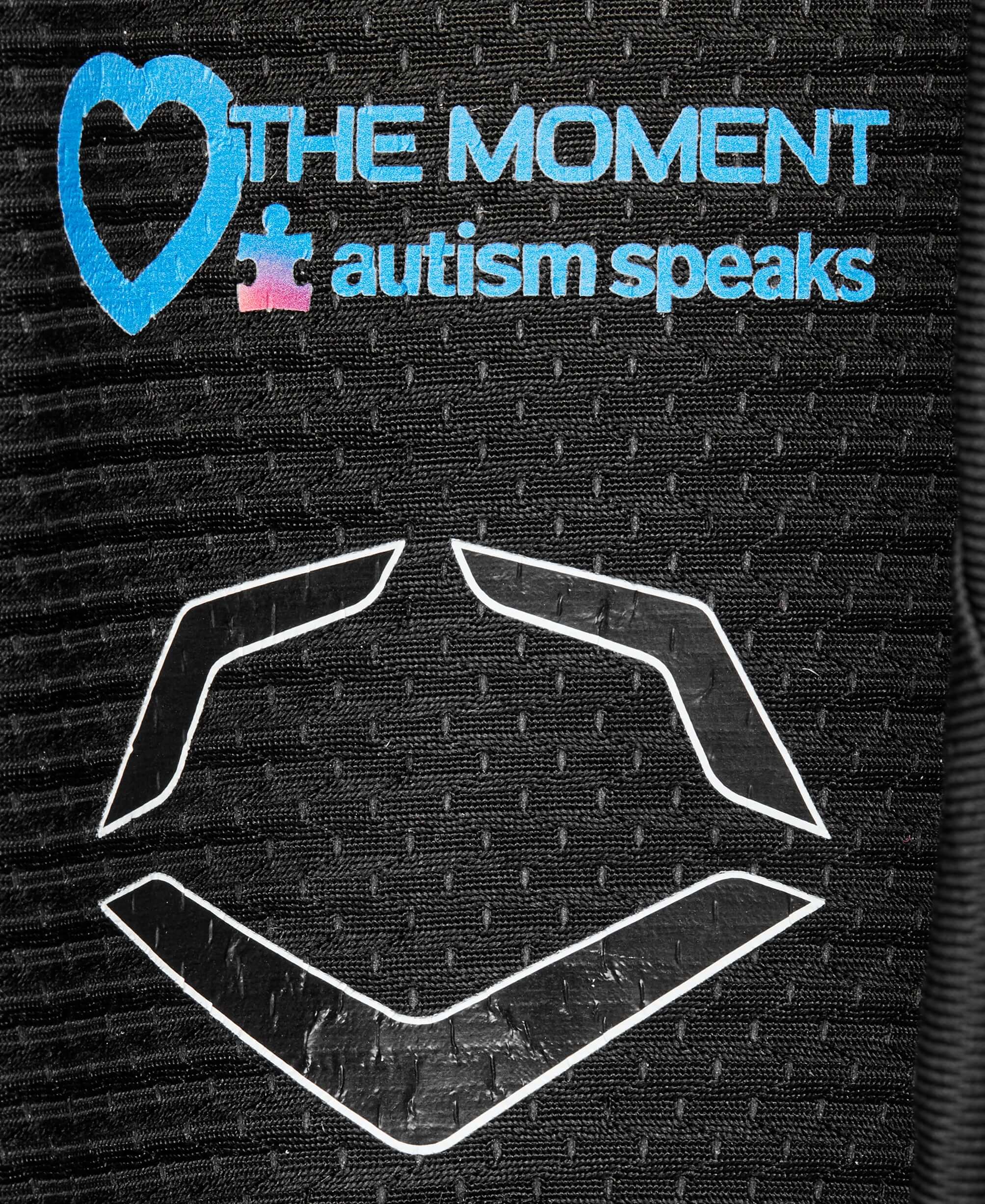 Evoshield Autism Speaks logo on leg guard featuring "The Moment" graphic in blue and purple against a black background.