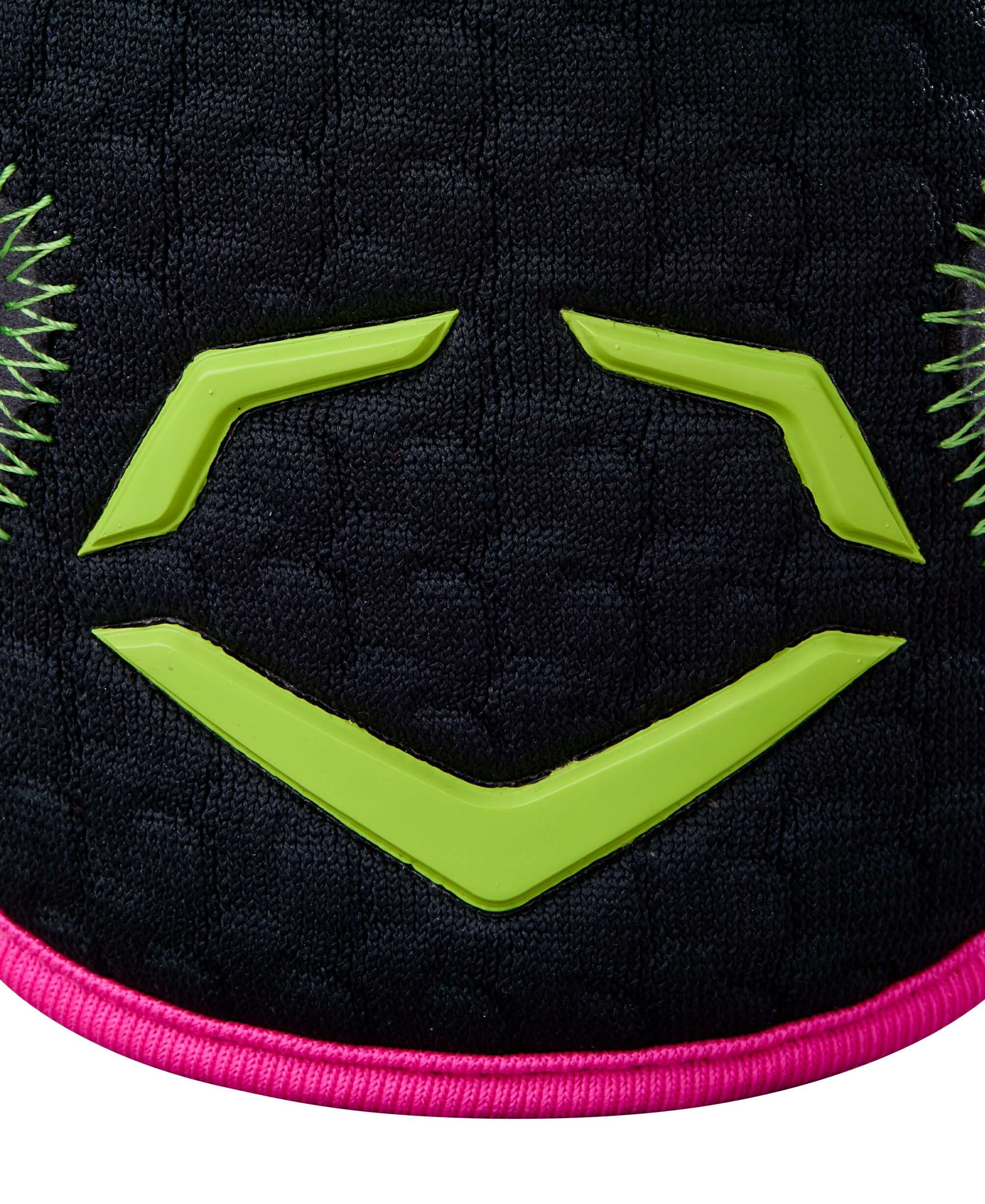 Close-up of Evoshield X-SRZ elbow guard with black fabric, green logo, and pink trim for sporty protection.