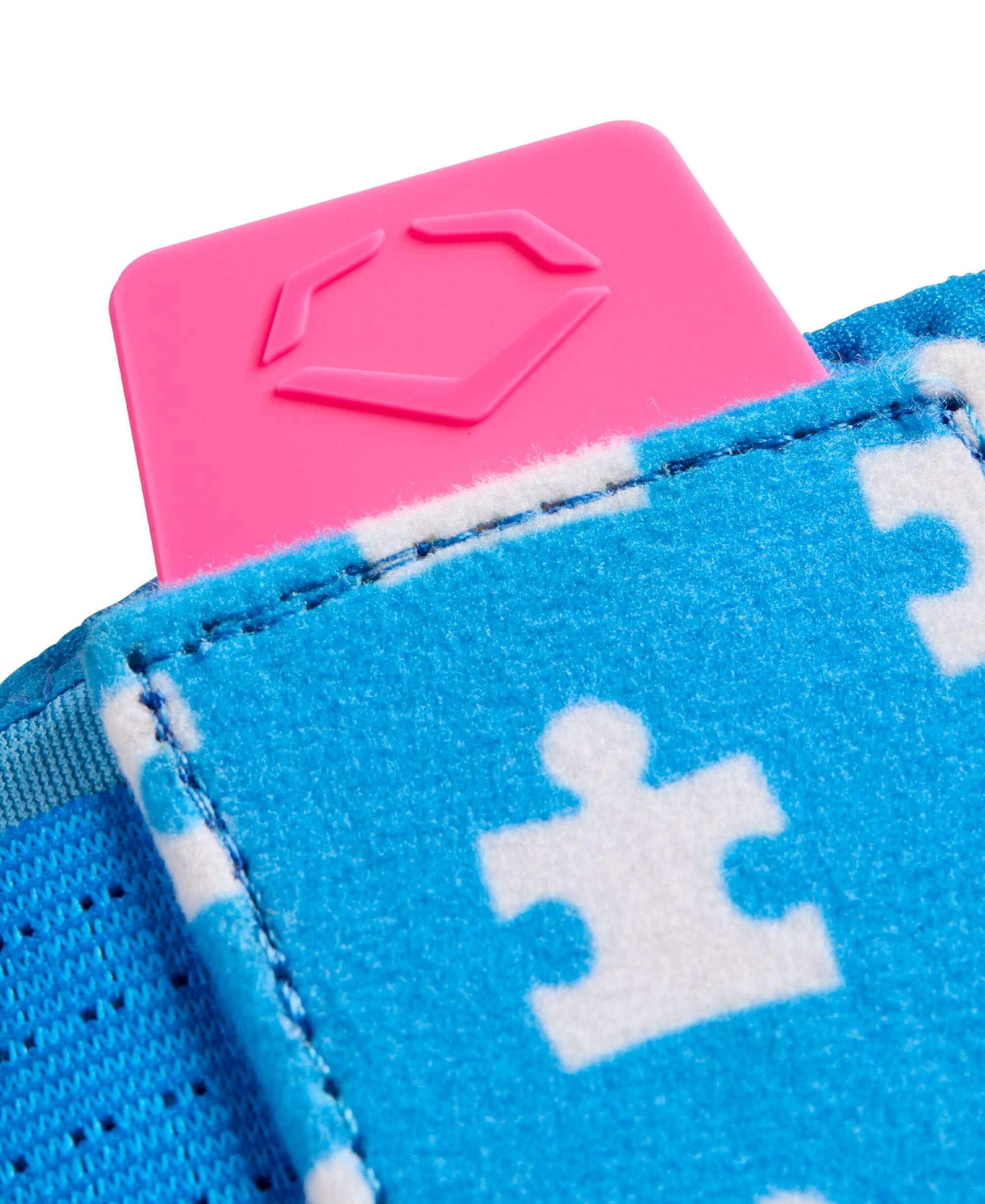 Close-up of the EvoShield X-SRZ Love the Moment Sliding Mitt 2.0 featuring blue puzzle pattern and pink tag.