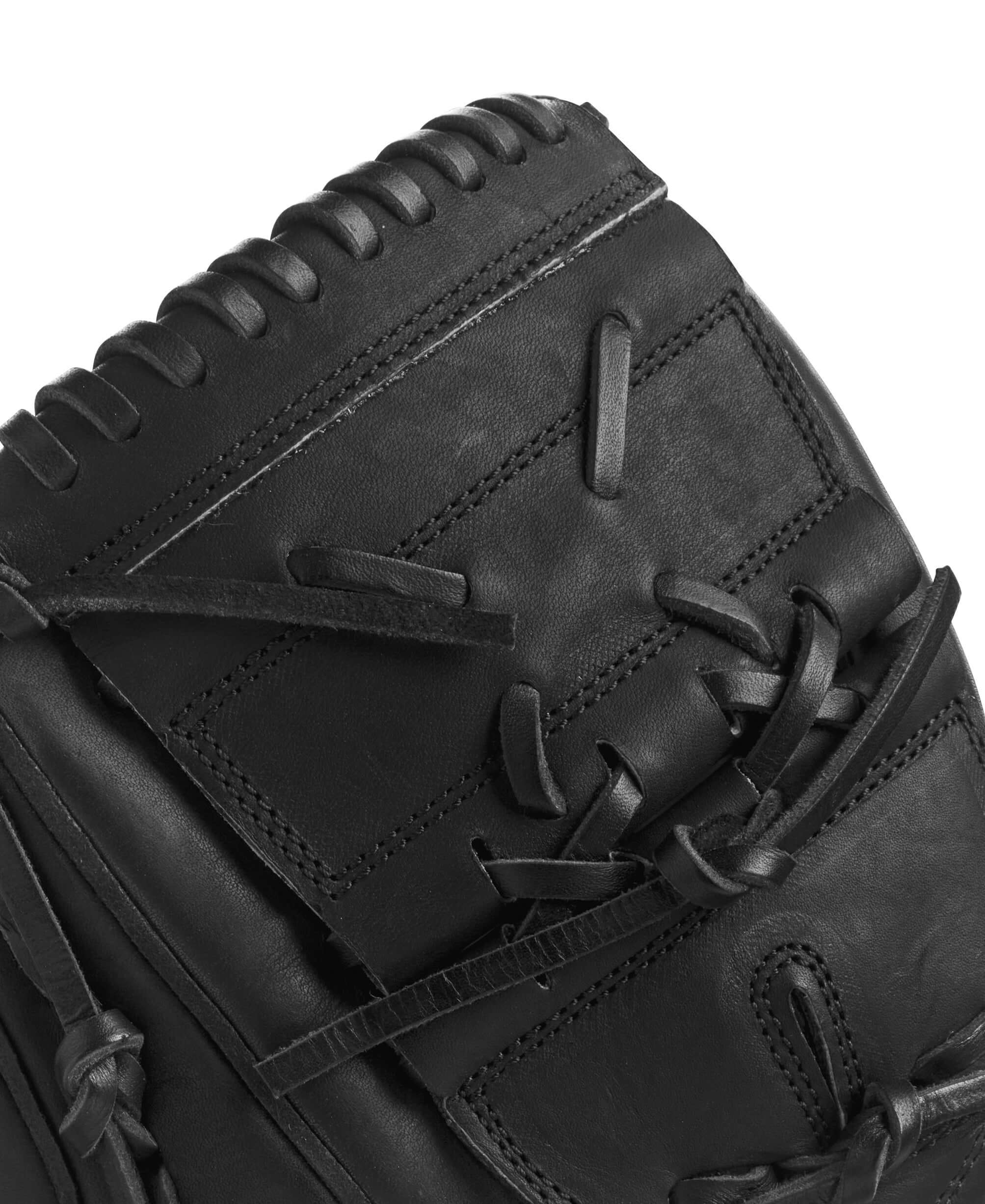 Close-up view of black Wilson A2000 CK22 glove showcasing leather details and traditional lacing design.