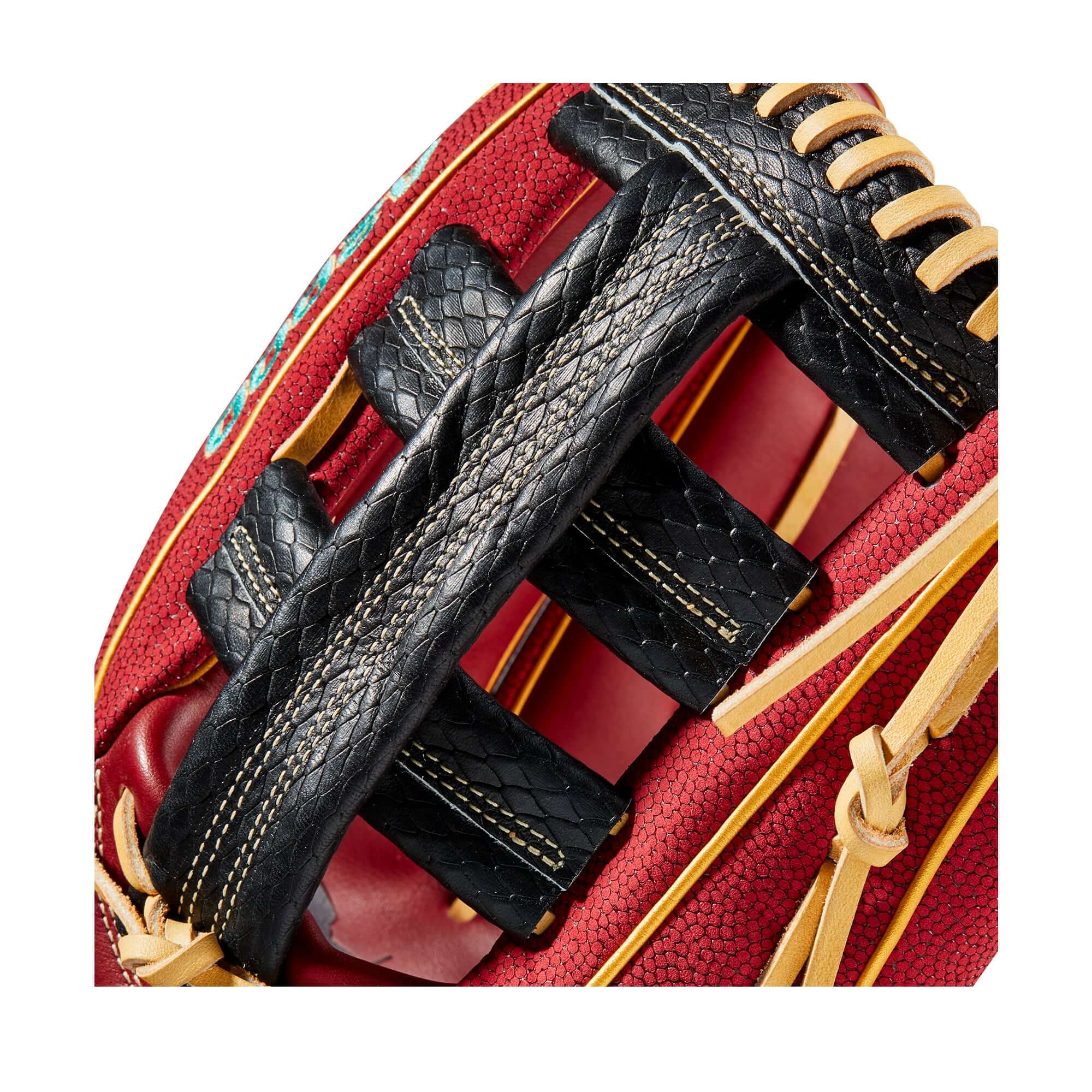 Close-up of Wilson 100 GOTM glove, showcasing black leather lacing on brick red background for superior grip.