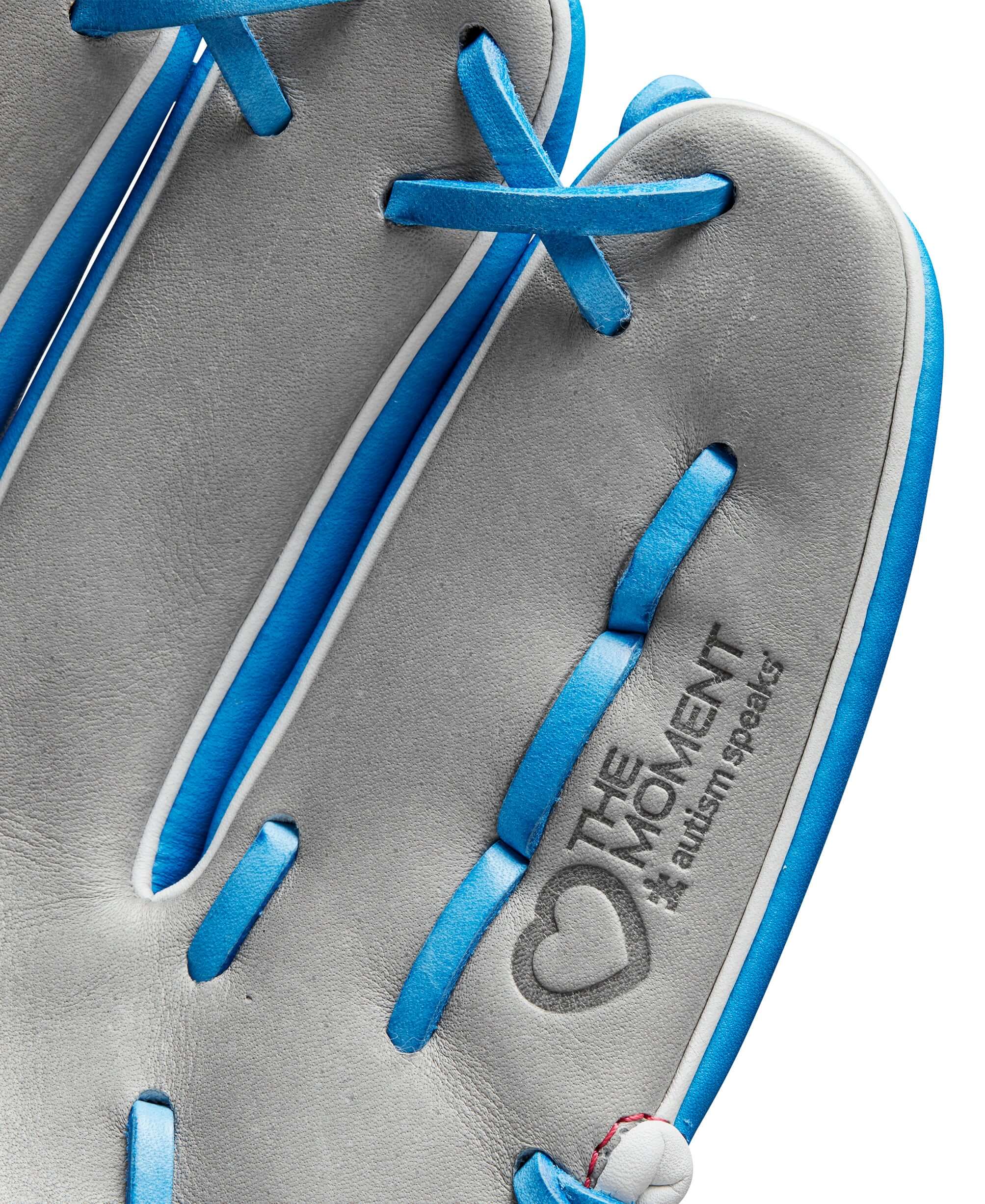 Close-up of the interior of the Wilson A2000 glove featuring the Autism Speaks Love The Moment logo in blue and grey.