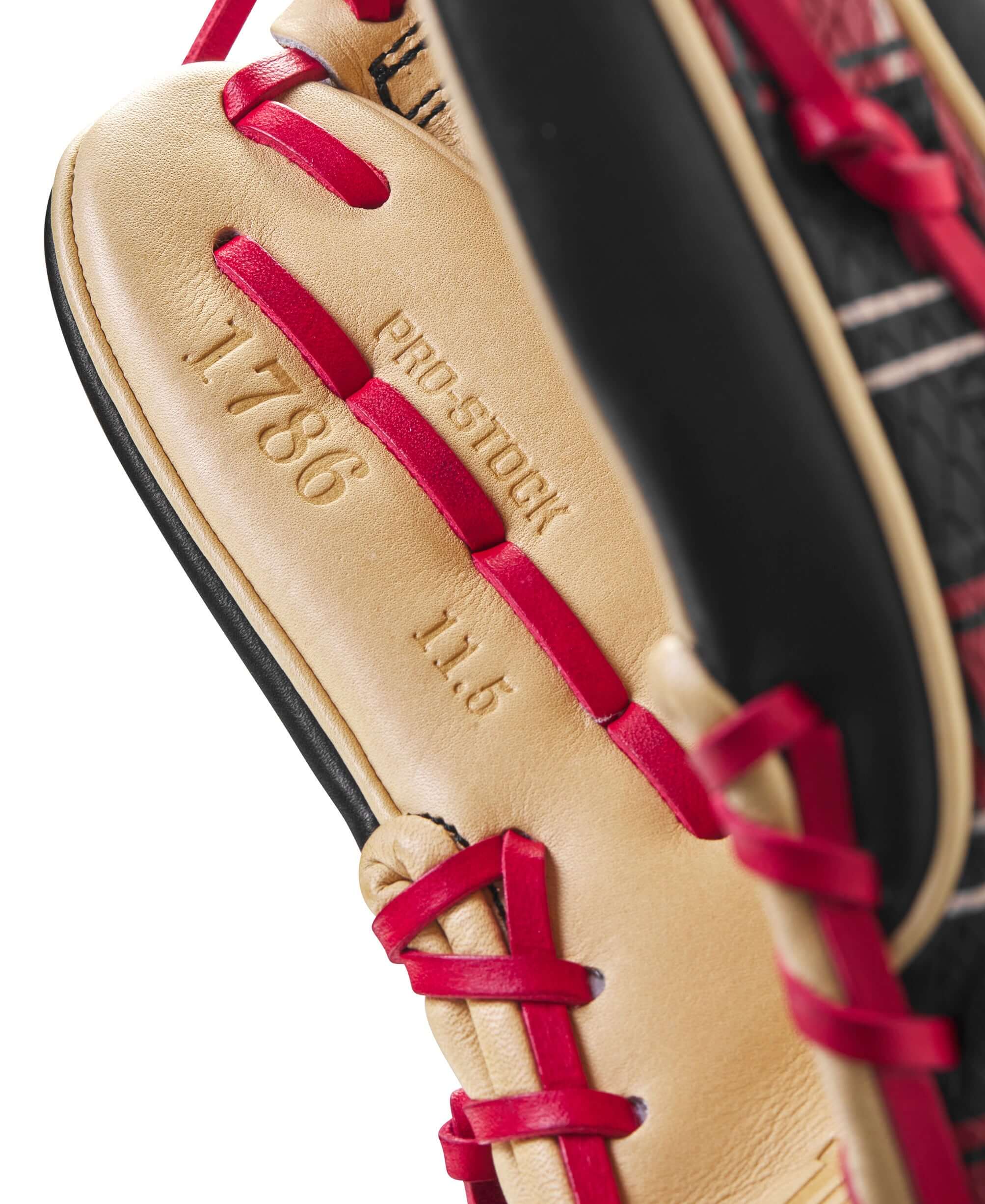 Close-up of Wilson A2000 GOTM glove showing Pro Stock details, model 1786, and 11.5" size with vibrant red laces.