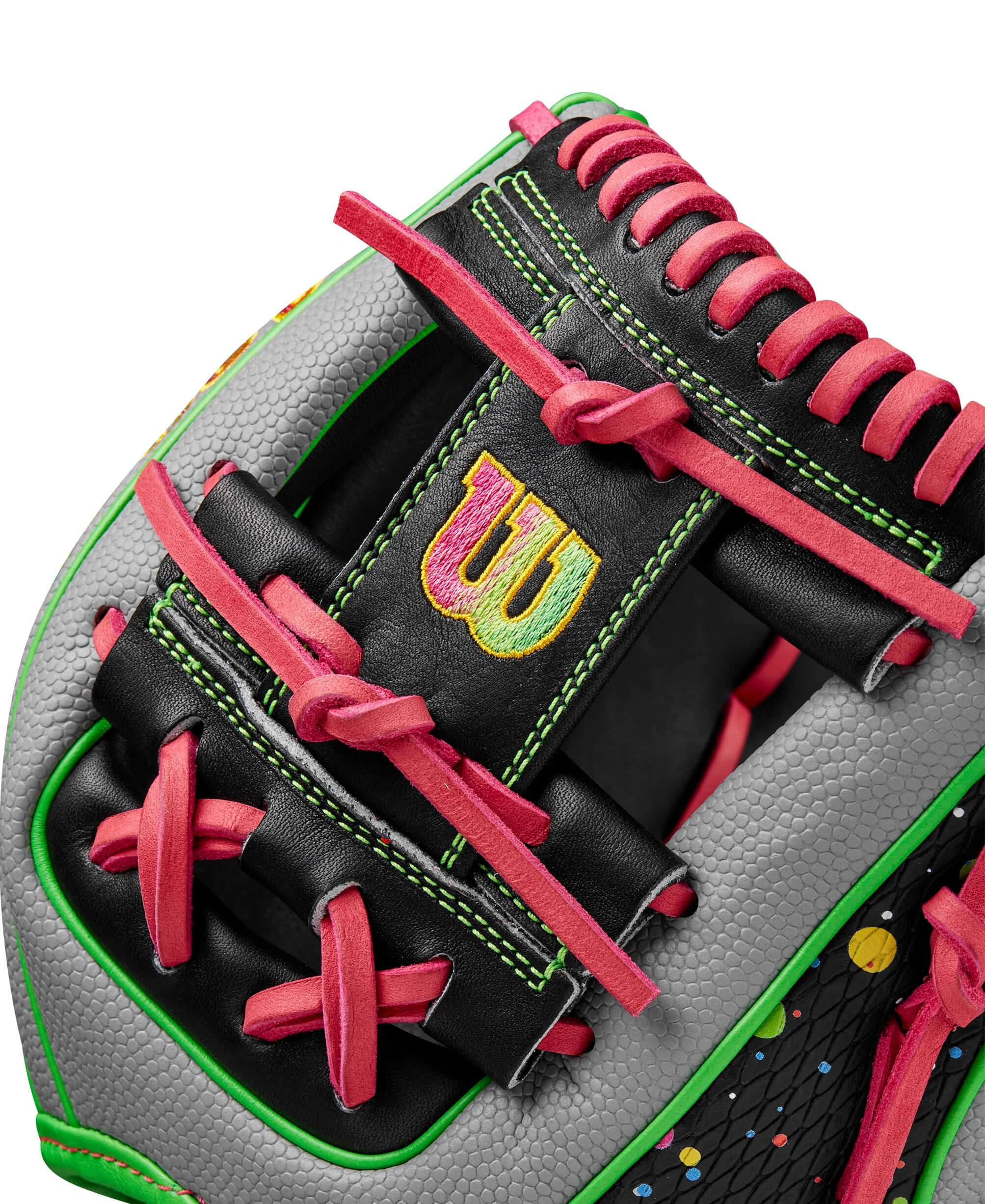 Close-up of Wilson A2000 1786SS baseball glove showing vibrant pink laces and neon green accents against black leather.