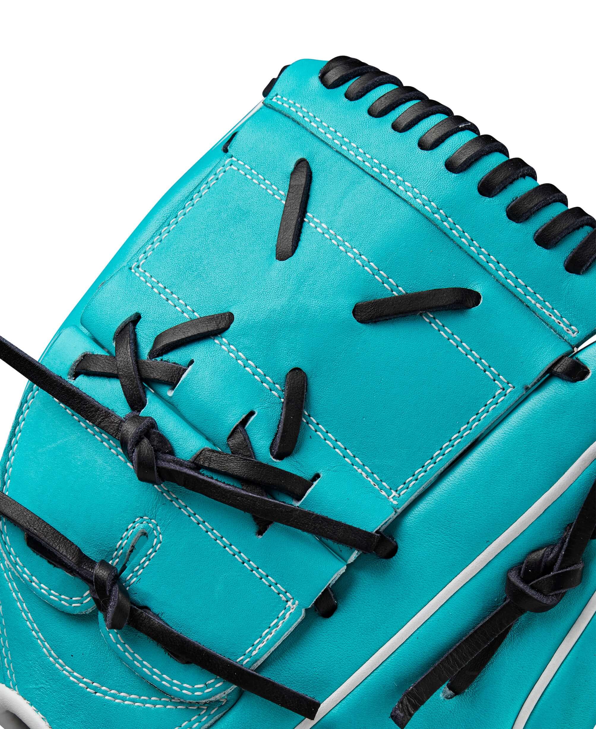 Close-up of Wilson Spring 2025 A2000 SA17 gloves featuring teal leather, black laces, and modified wrist strap for baseball pitching.