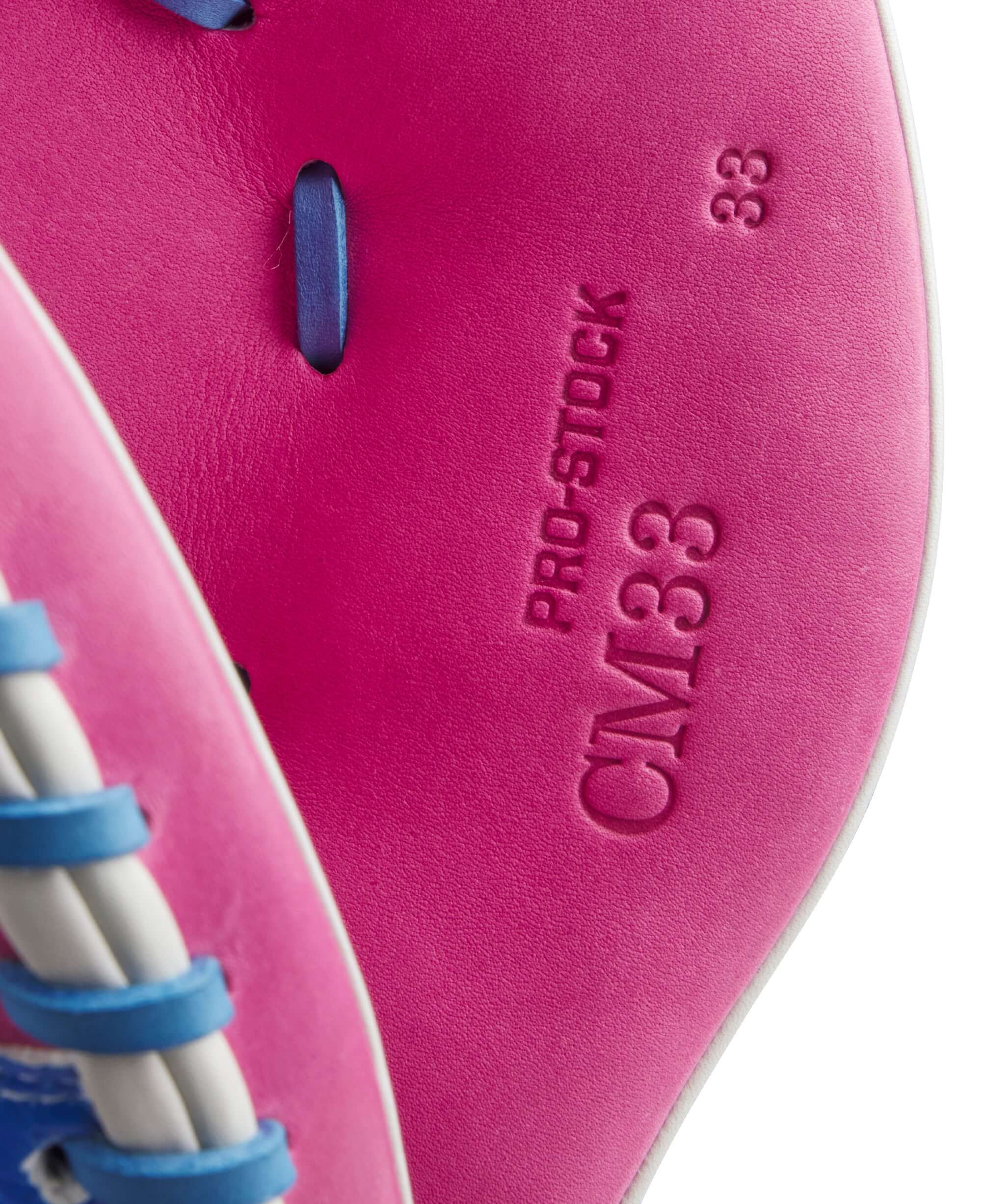 Close-up of the Wilson A2000 CM33SS mitt showing Flamingo Pink Pro Stock leather and CM33 stamp details.