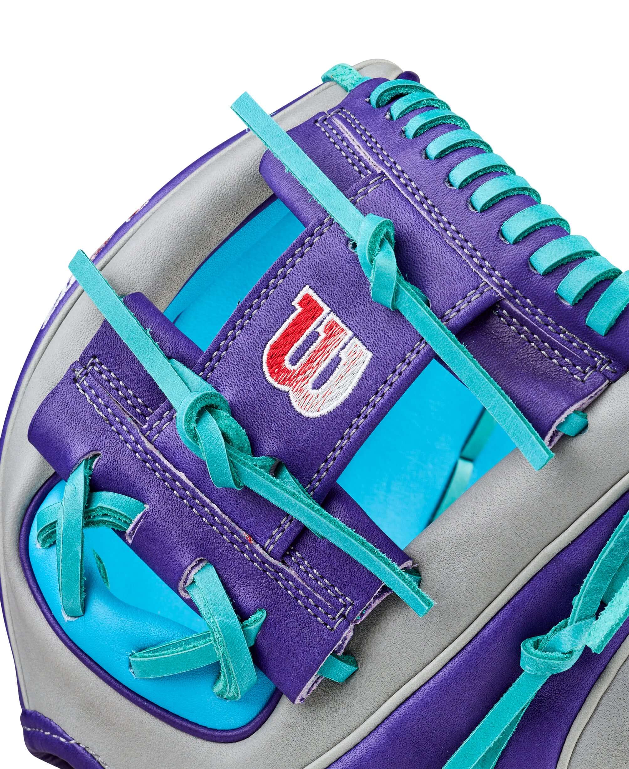 Web detail of Wilson Spring 2026 A2K MB1975 11.75" Infield Baseball Glove, purple and teal lacing, close-up of logo patch.