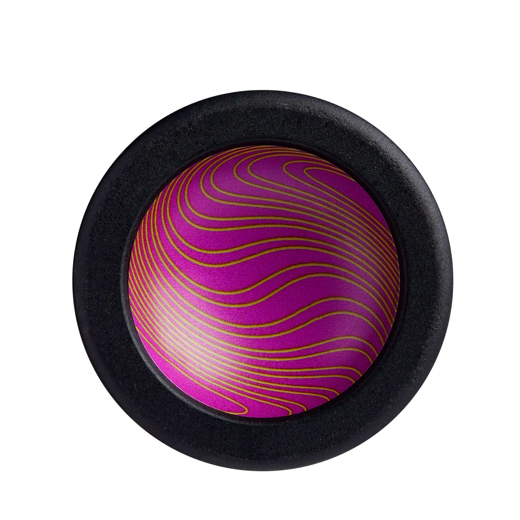 Colorful purple and gold swirling design on a round object with a black rim, perfect for decorative or playful purposes.