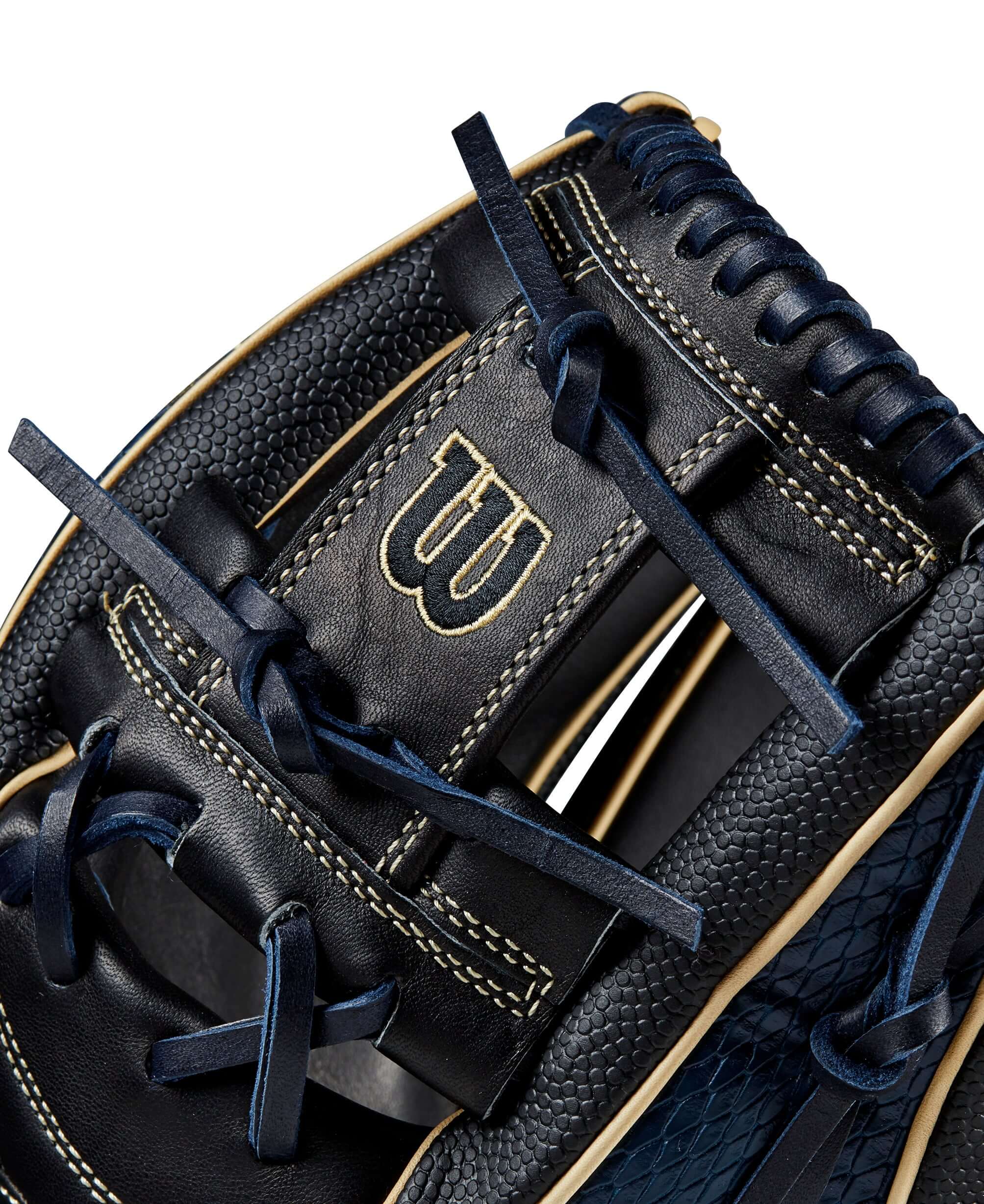 Close-up of the Wilson A2K 1723 glove showing navy and black leather detail, gold branding, and intricate lacing design.