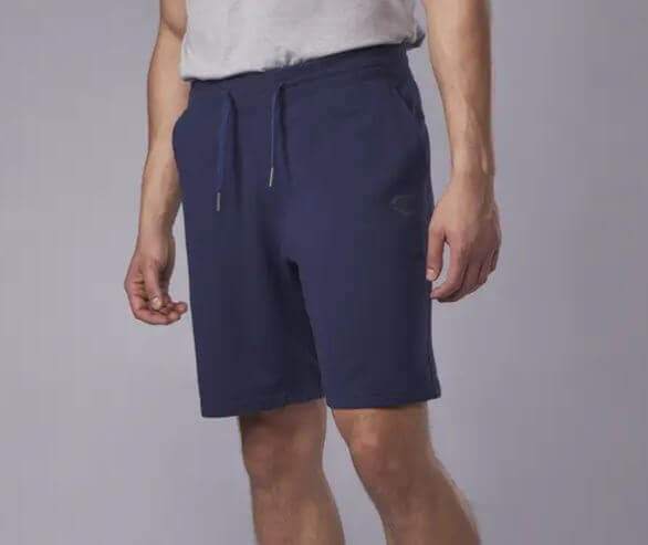 Model wearing Evoshield Pro Team Clubhouse Shorts in navy, front side view showing elastic waistband with drawcord and pockets.