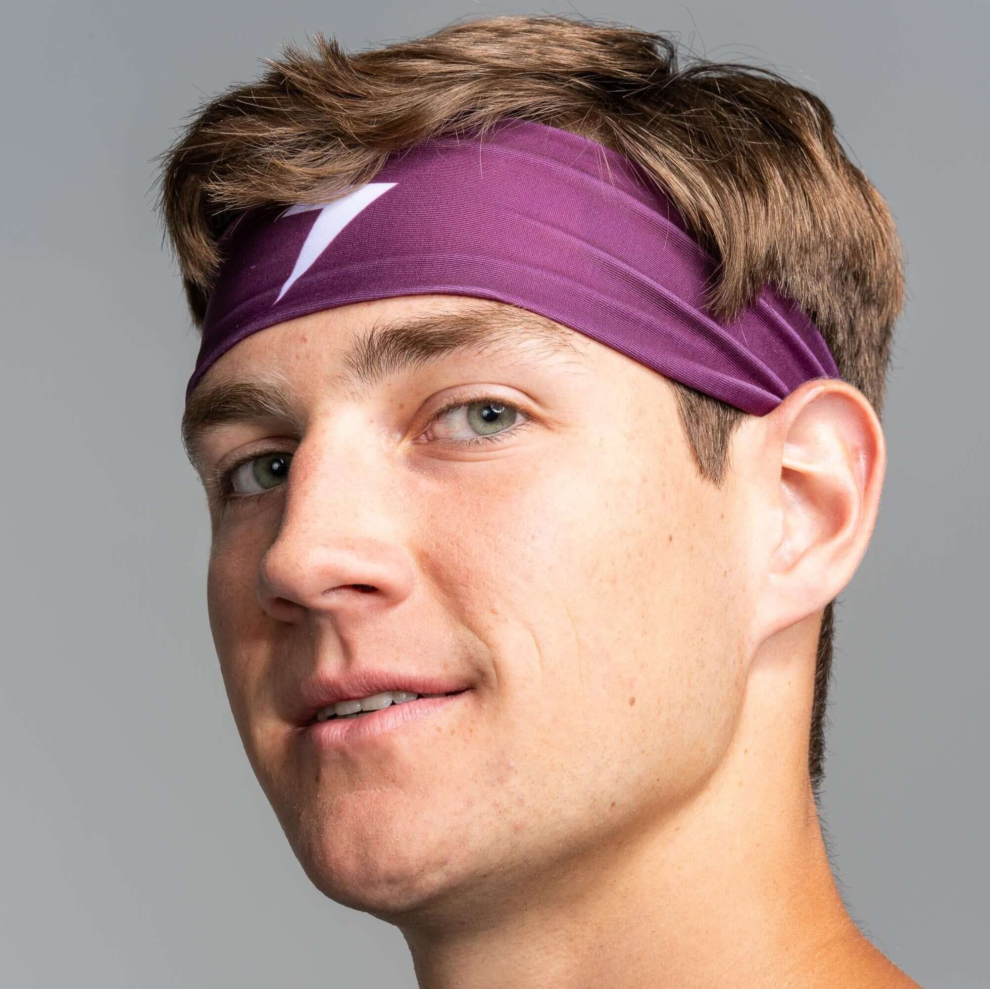 Bruce Bolt Performance Headband in purple worn by a man, designed for keeping sweat away during workouts.