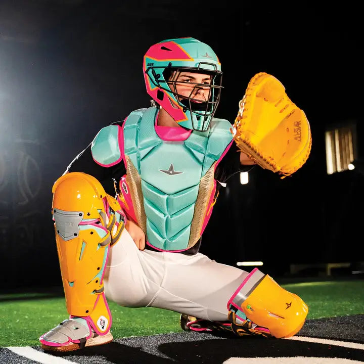 Catcher in All-Star MVP-Pro Short Fuse Catcher's Kit | Saved By The Bell Limited Edition | Yellow/Pink/Seafoam, kneeling on field.