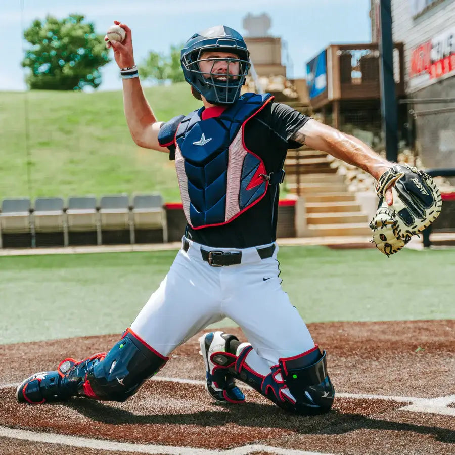 Player wearing All-Star MVP-PRO™ Chest Protector in black/blue color, NOCSAE certified, kneeling in throwing position on baseball field.