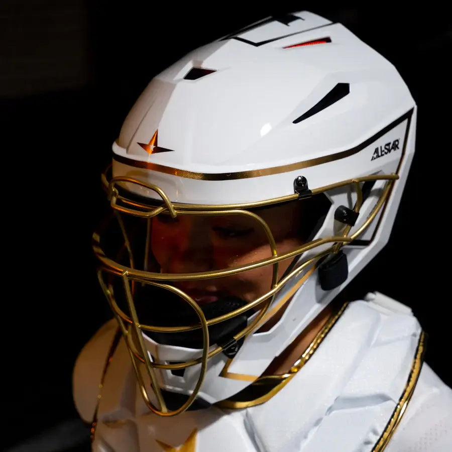 All-Star MVP Pro PHX™ Diamond Series Softball Catcher's Helmet in White/Gold, side view showing gold cage and logo detail