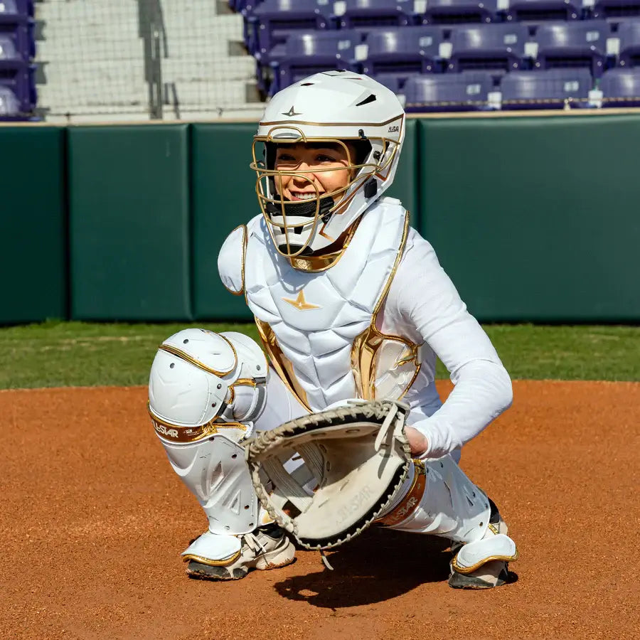 Player wearing All-Star MVP Pro PHX™ Diamond Series Softball Catcher's Kit | White/Gold (Small), catching stance on field.
