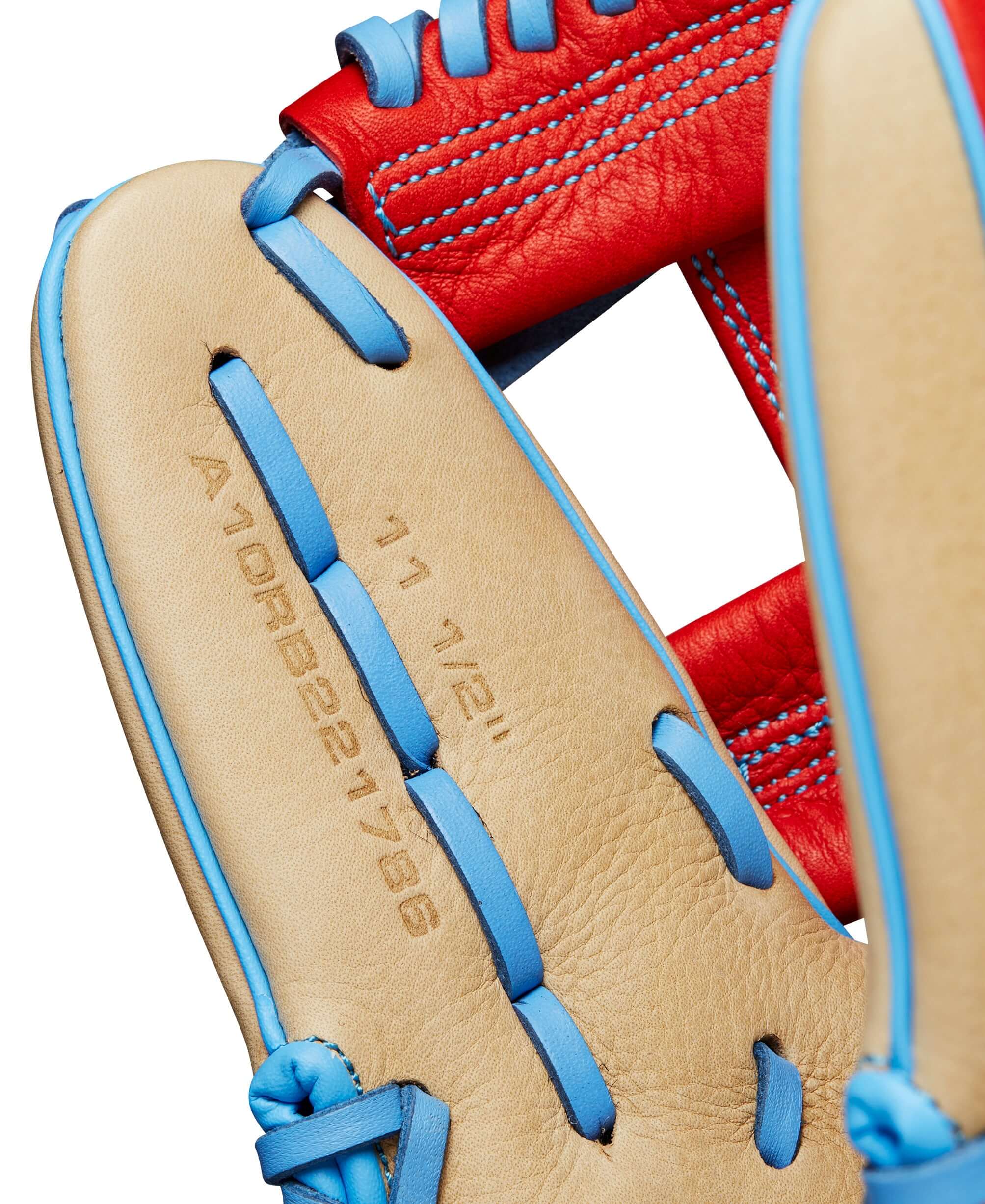 Close-up of Wilson 2024 A1000 1786 infield baseball glove showing 11.5" size and detailed stitching in blonde, red, and blue leather.