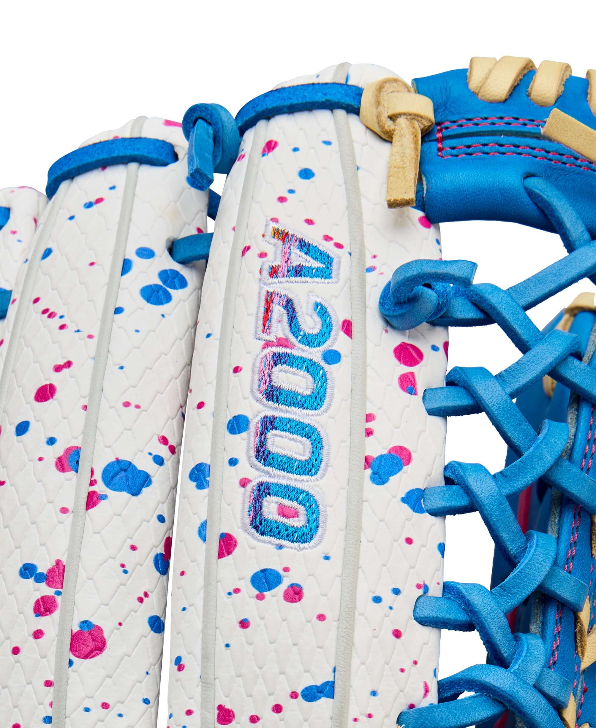Close-up of Wilson A2000 T125SS glove featuring colorful splatter design and blue accents for fastpitch softball.
