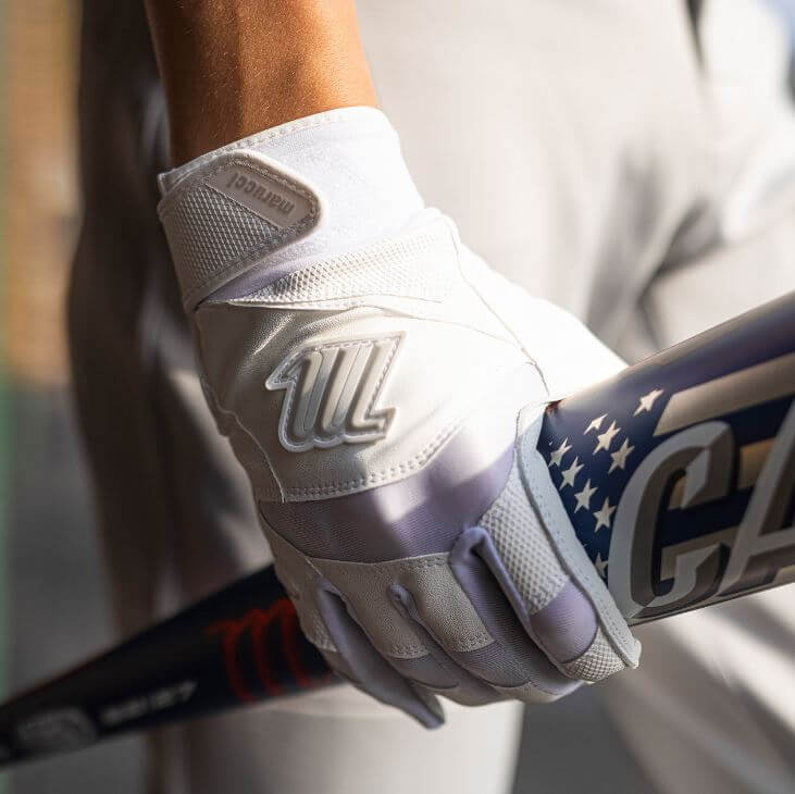 Marucci Signature Adult Batting Glove in white, featuring grip, durability, and ergonomic design, held while gripping a bat.
