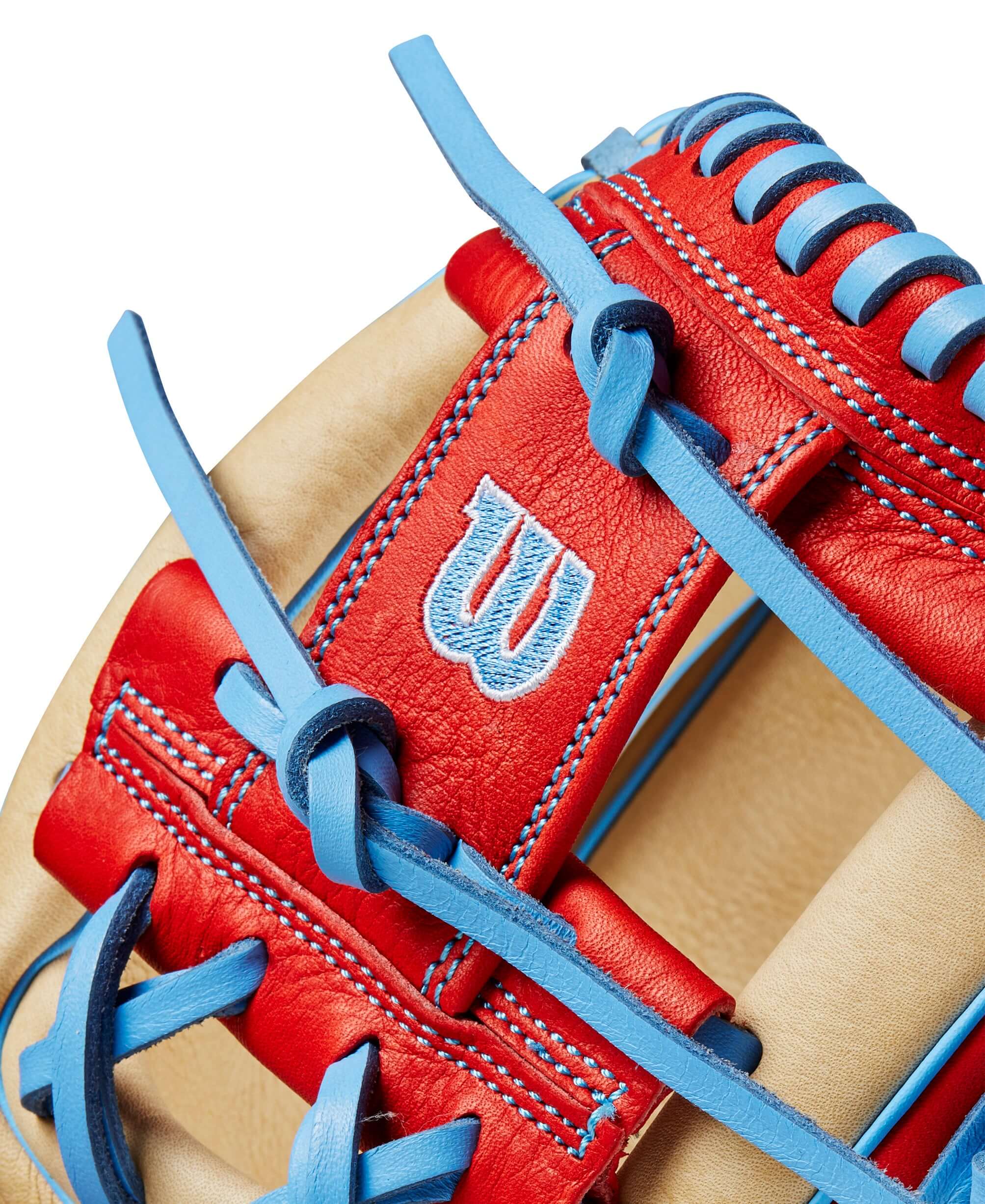 Close-up of the Wilson A1000 1786 infield baseball glove in blonde, red, and blue leather with signature logo.