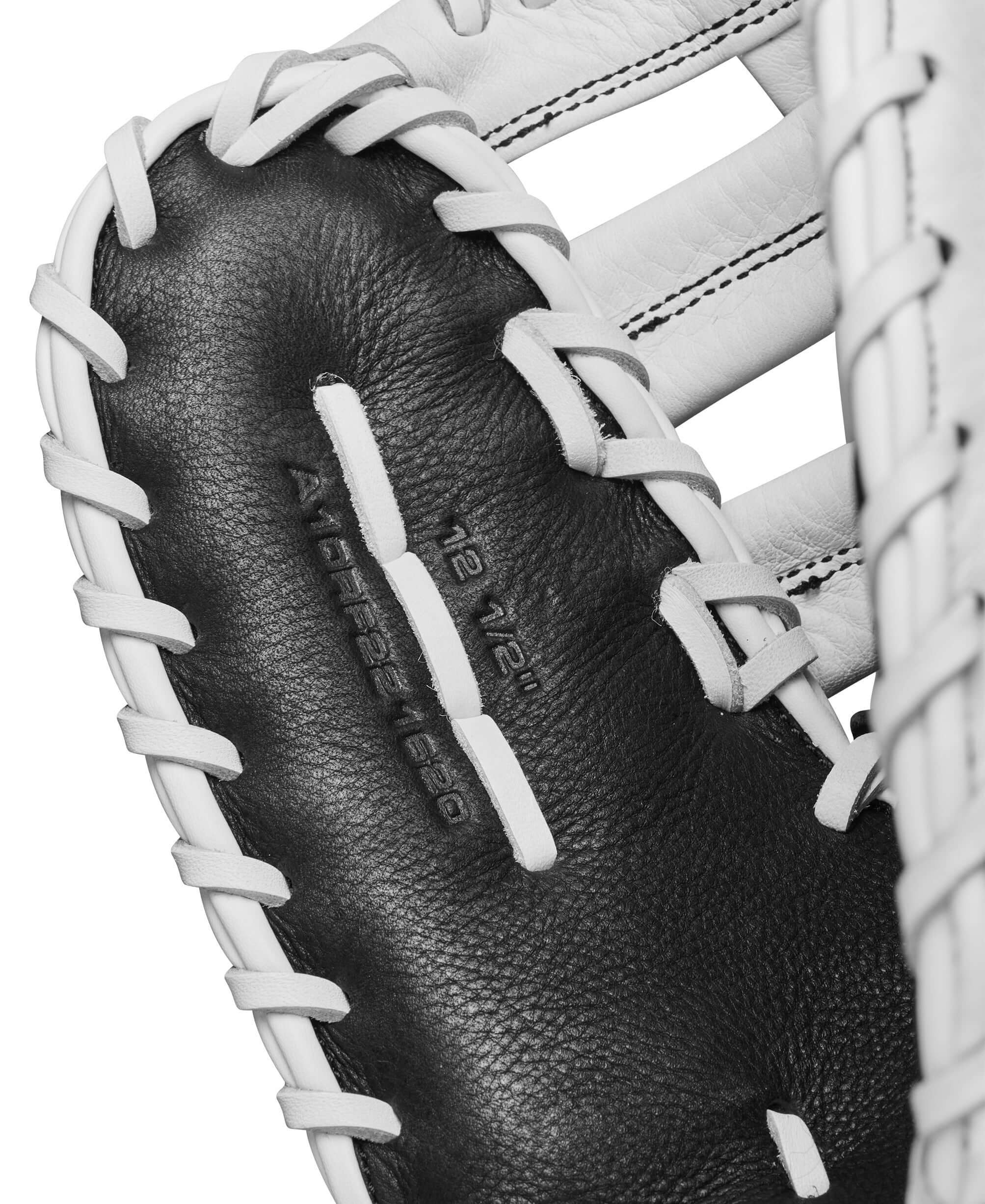 Close-up of Wilson A1000 1620 first base mitt showing black and white leather interior with size markings.