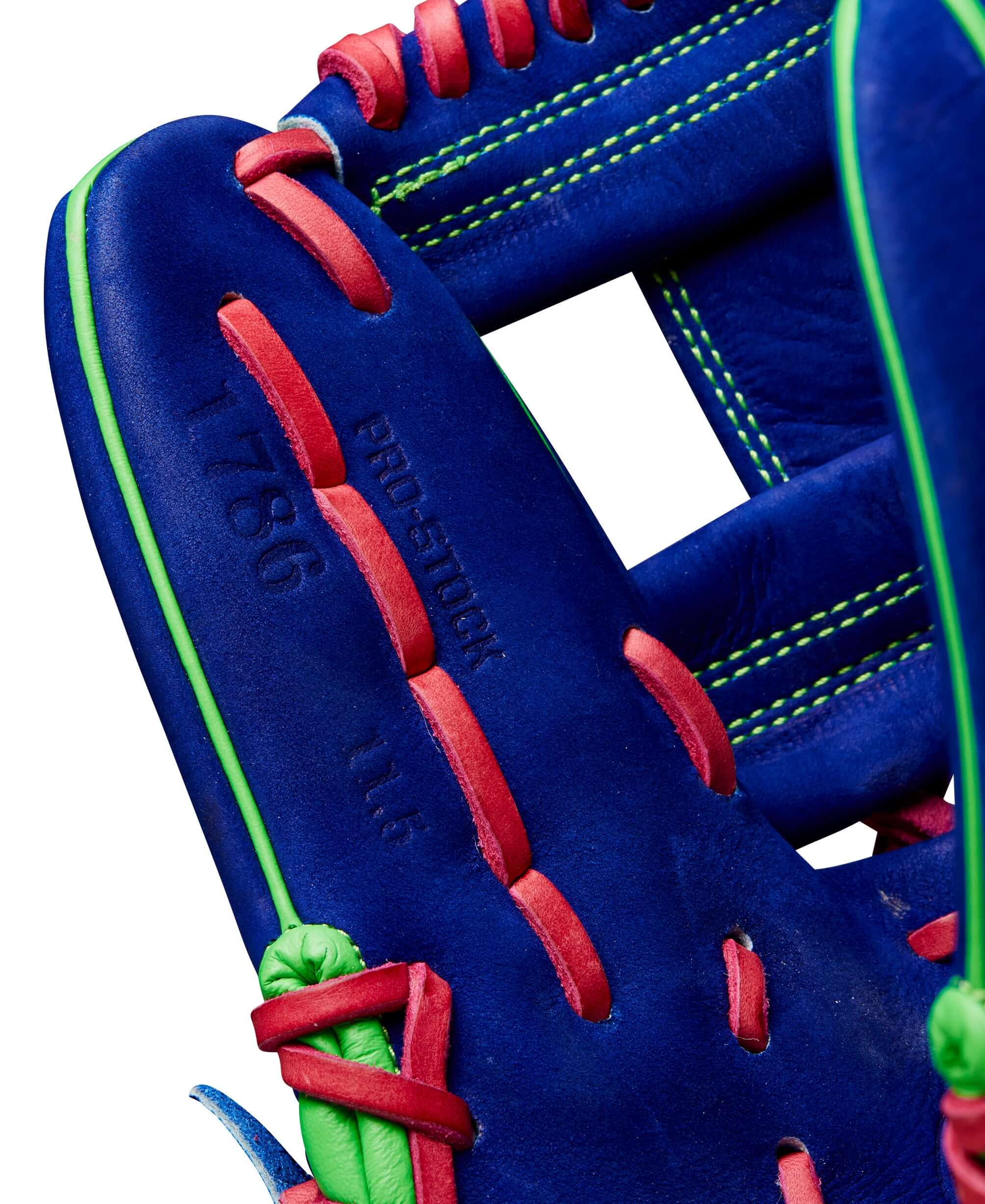 Close-up of Wilson A2000 1786 glove featuring blue Pro Stock leather, neon green and pink accents, and H-Web design.