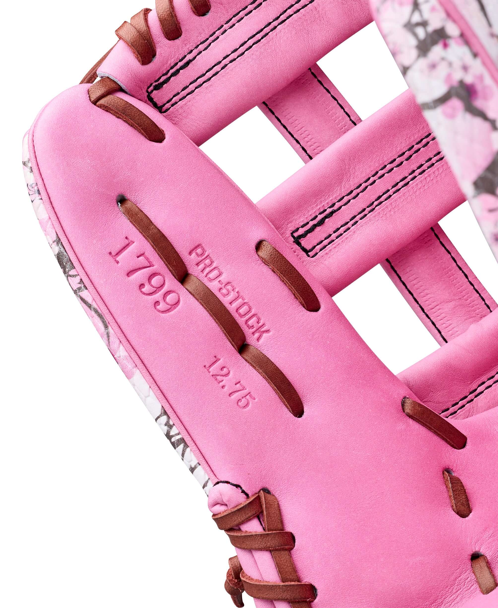 Close-up of the Wilson A2000 1799 MG baseball glove, featuring pink leather and floral design, highlighting model details.