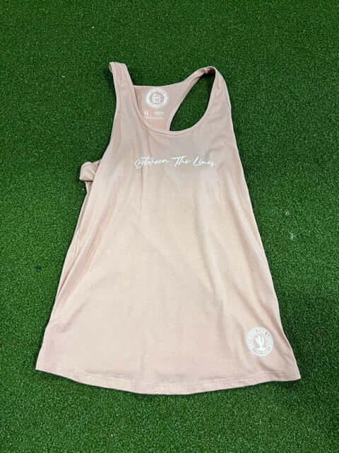 Between The Lines Racerback Women's T-Shirt in light pink, soft cotton, casual sleeveless design on green background.