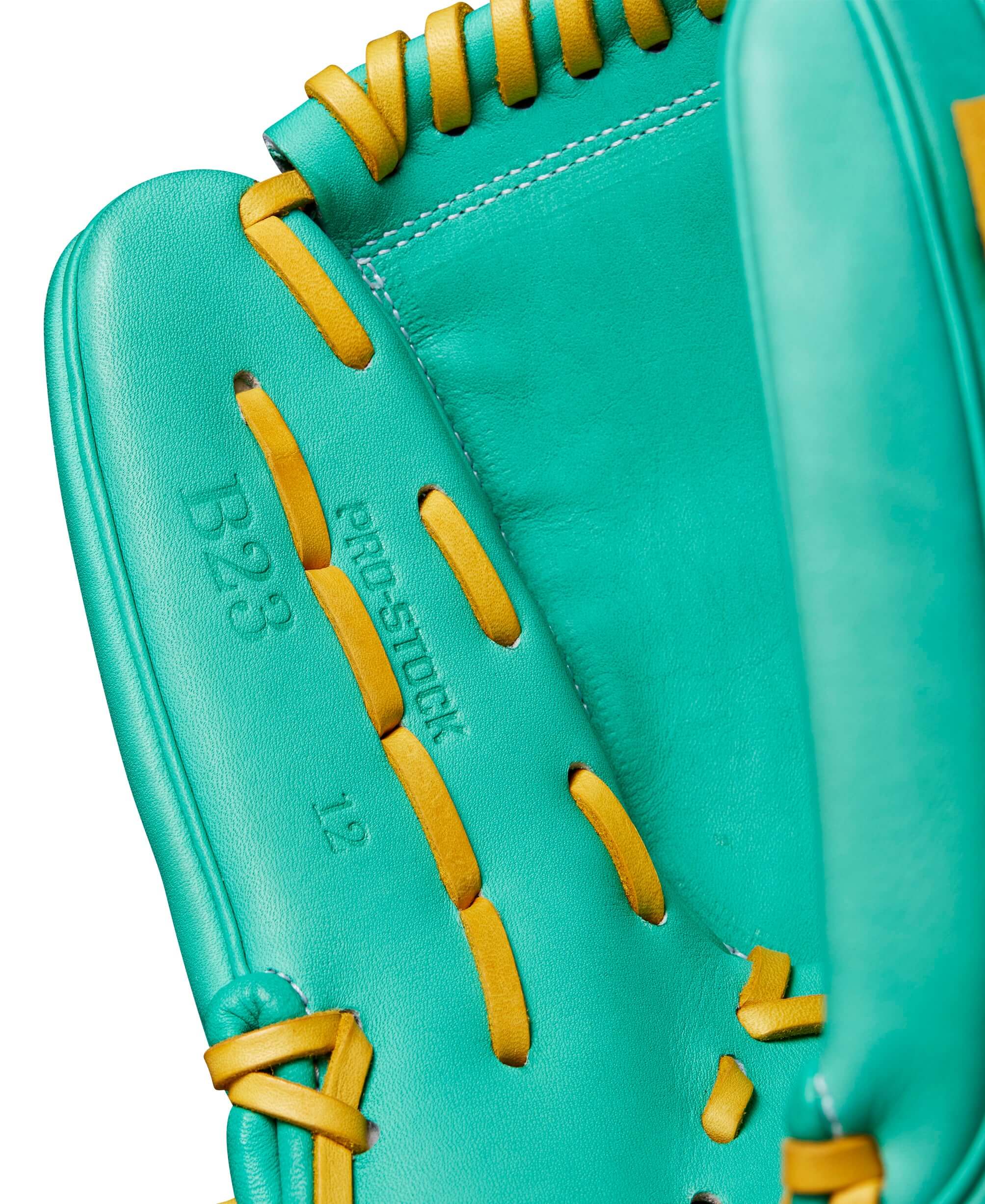 Close-up of the Wilson A2000 B23 pitcher's glove in seafoam green and yellow, highlighting the pro-stock leather and 12" design.