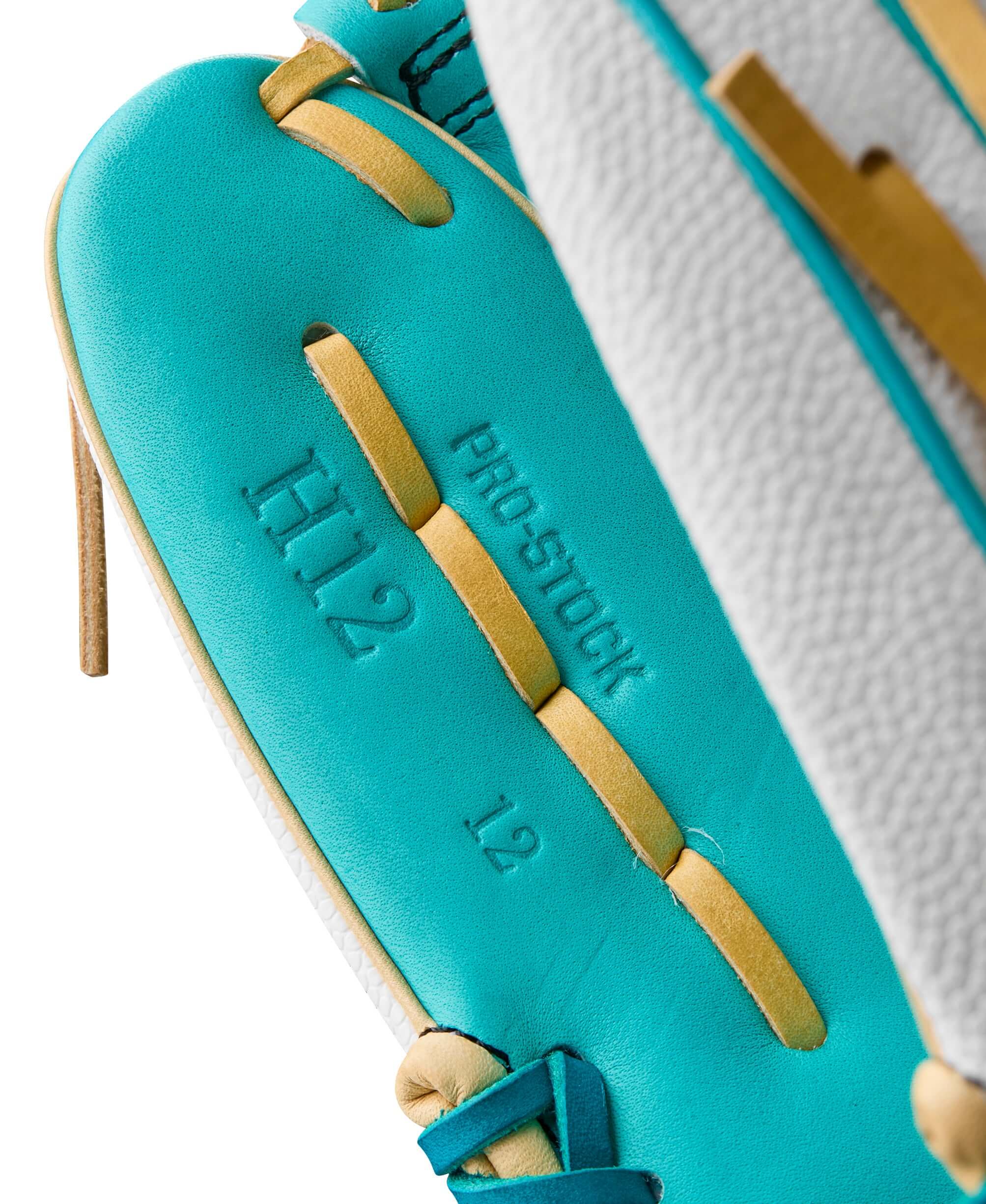 Close-up of Wilson A2000 H12SS fastpitch softball glove detailing teal and white leather with Pro Stock embossed.