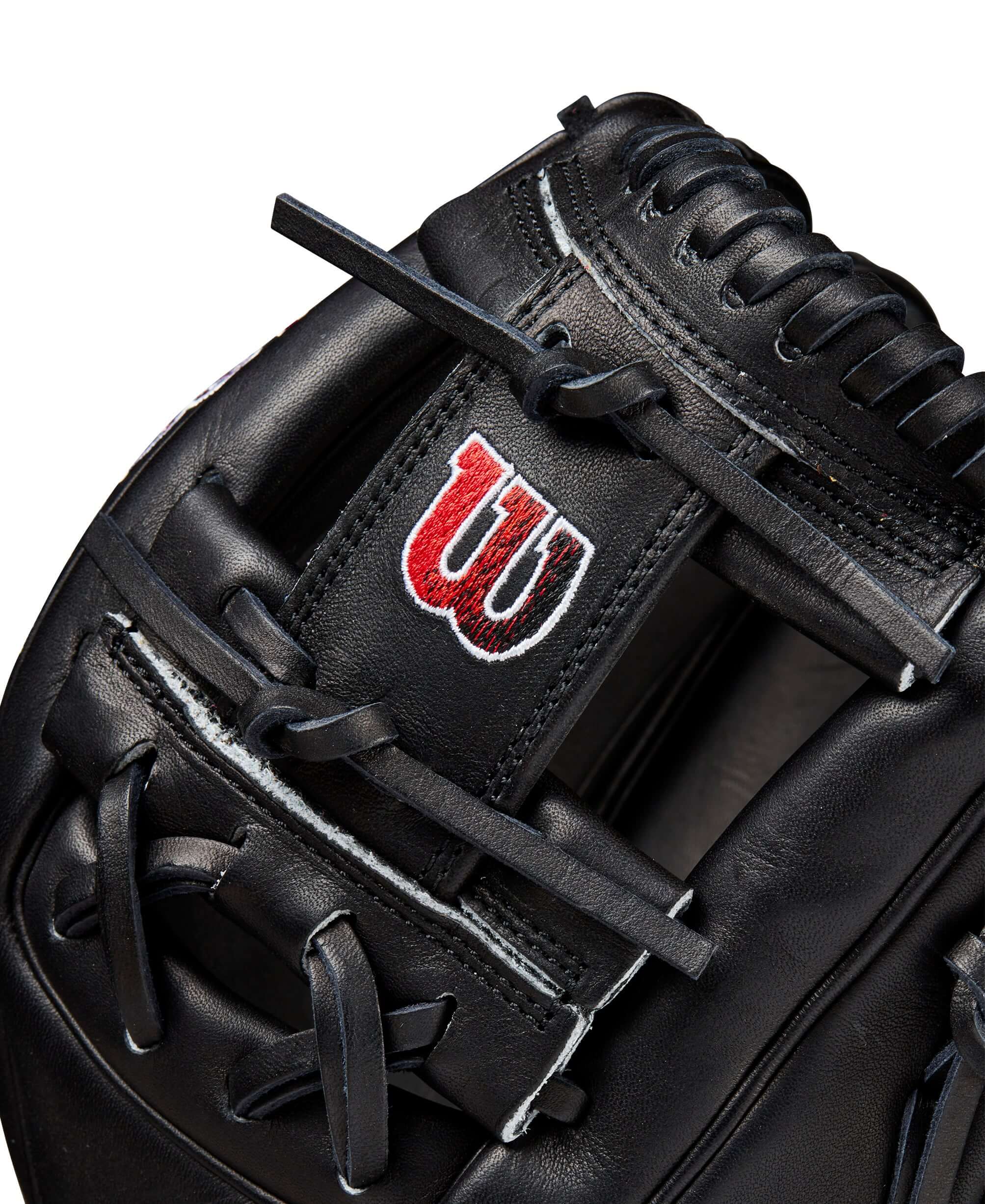 Wilson A2000 1786 glove detail showing all-black Pro Stock leather and red gradient logo for performance and style.