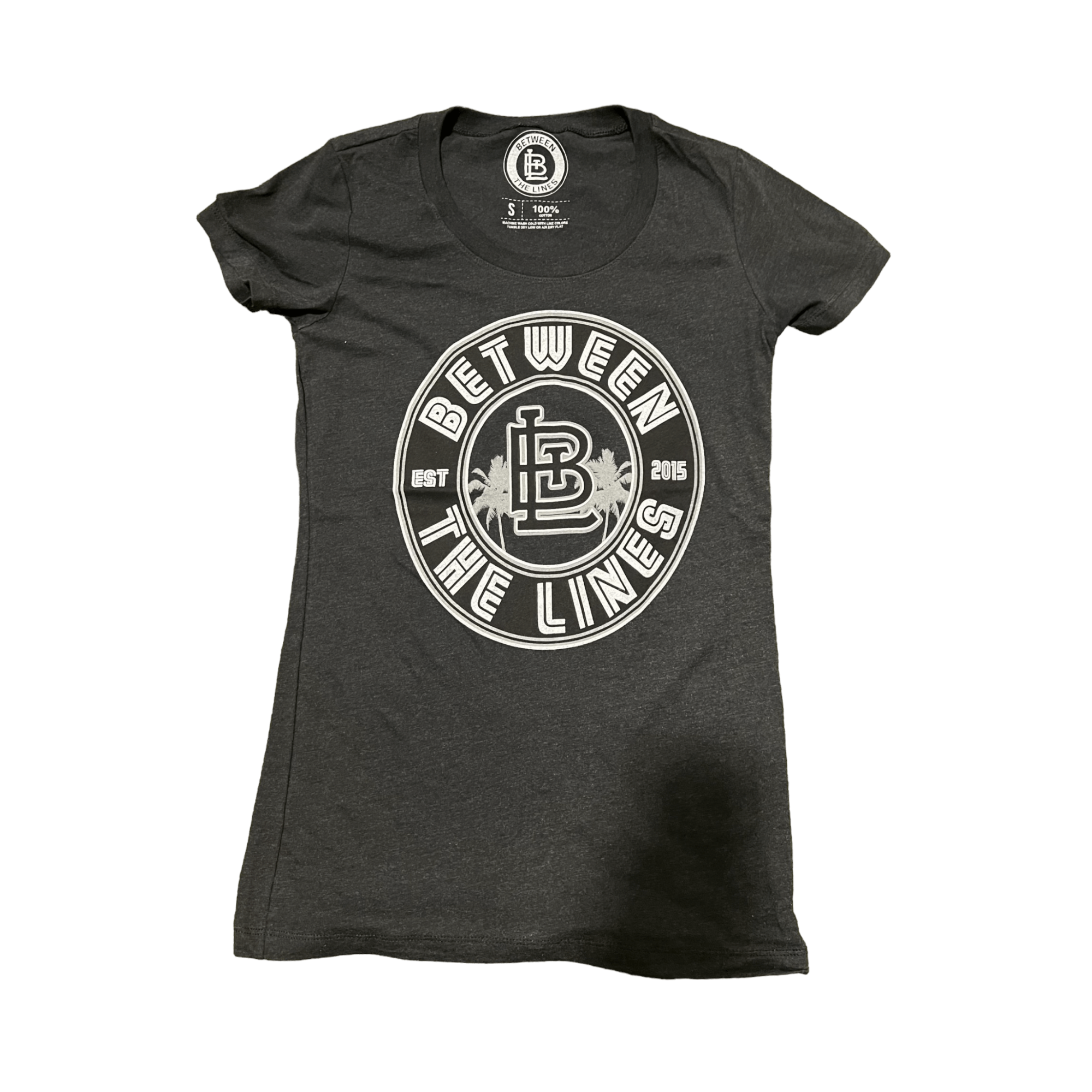 Between The Lines Women's Palm Tree T-Shirt in charcoal gray, featuring a stylish logo design and short sleeves. Perfect summer wardrobe choice.