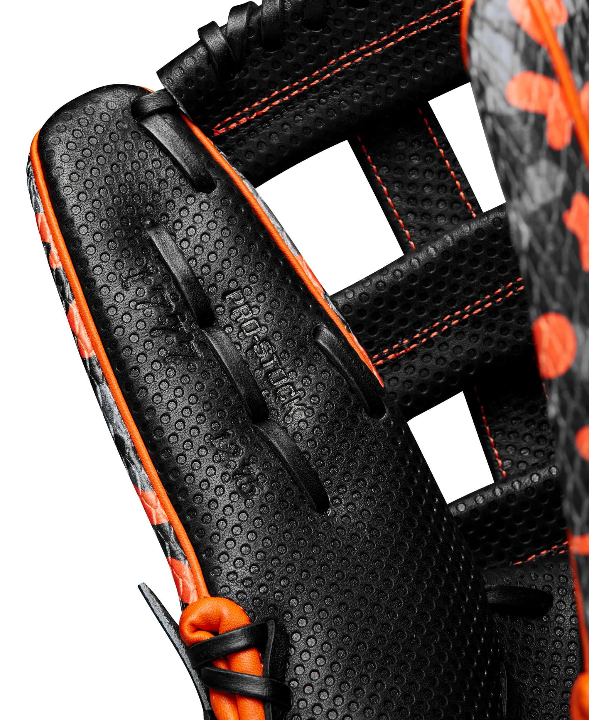 Close-up of Wilson A2000 1777 glove showcasing black and orange SuperSnakeSkin texture and dual post web design.