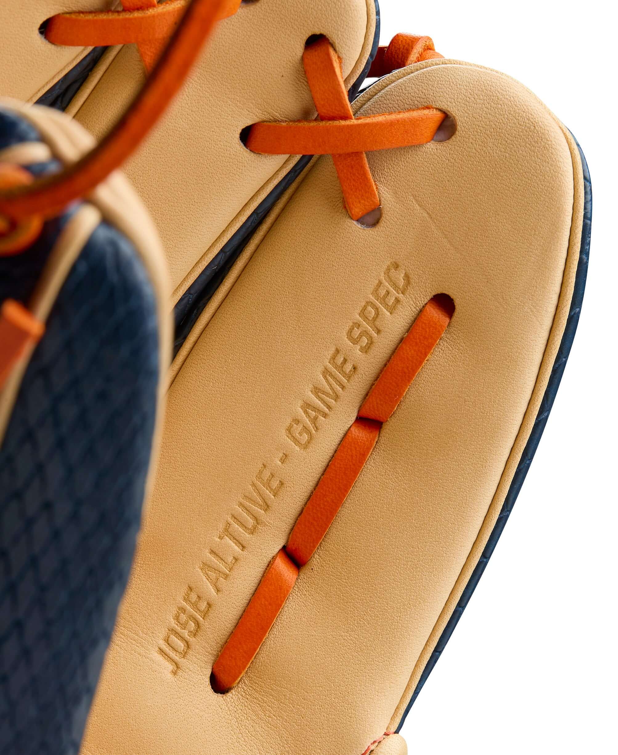 Close-up of Jose Altuve's A2000 glove showing game specification and color details in navy, blonde, and orange.
